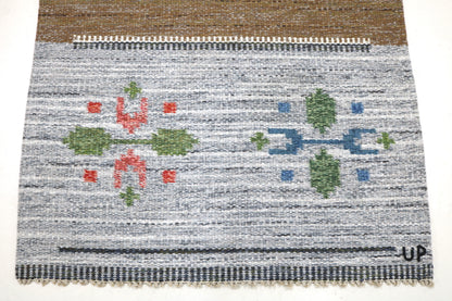Detail of vintage Swedish kilim rug showing handwoven texture, geometric motifs, and natural wool colours
