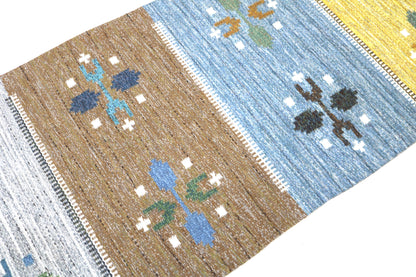 Detail of vintage Swedish kilim rug showing handwoven texture, geometric motifs, and natural wool colours
