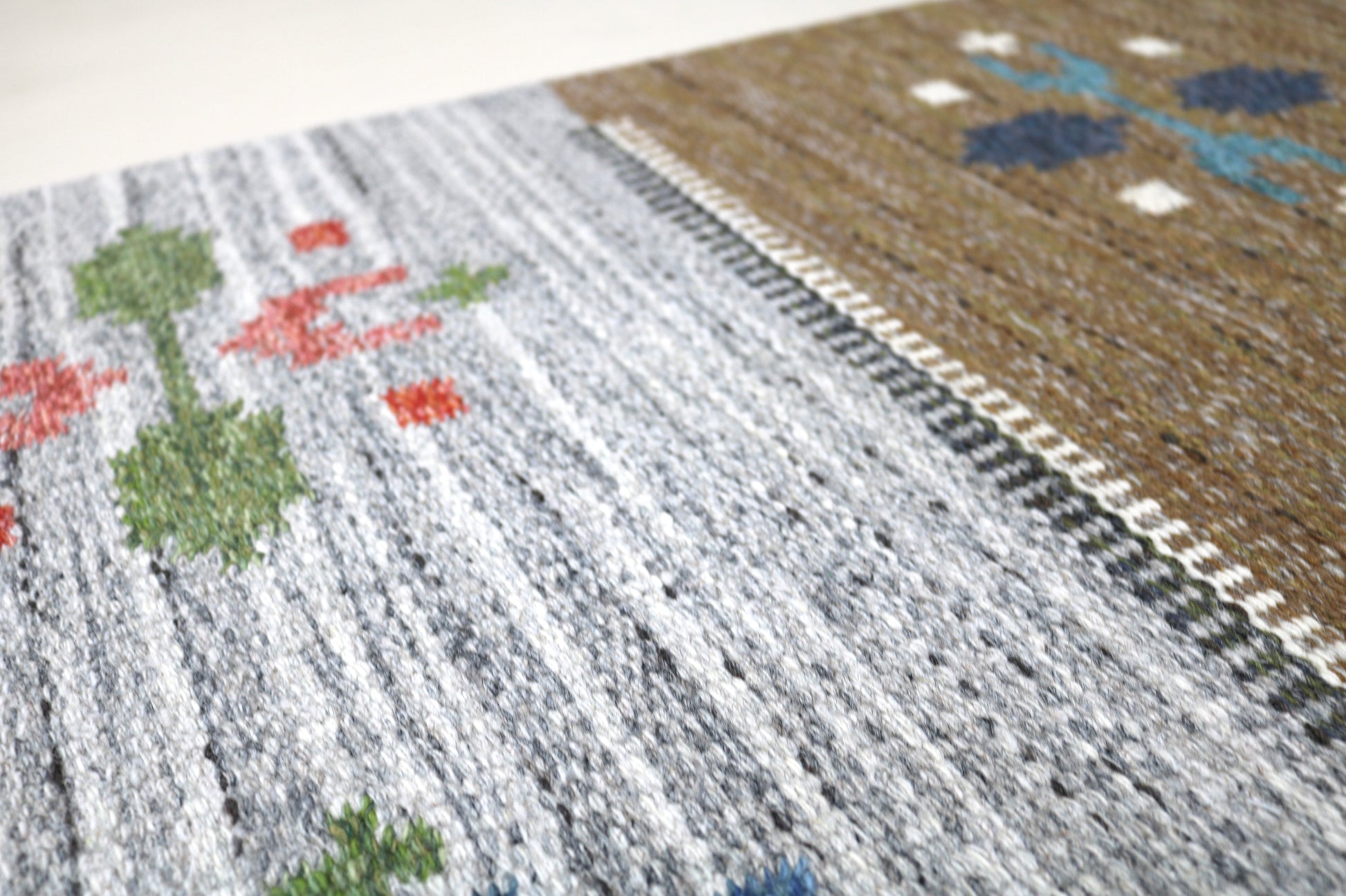 Detail of vintage Swedish kilim rug showing handwoven texture, geometric motifs, and natural wool colours

