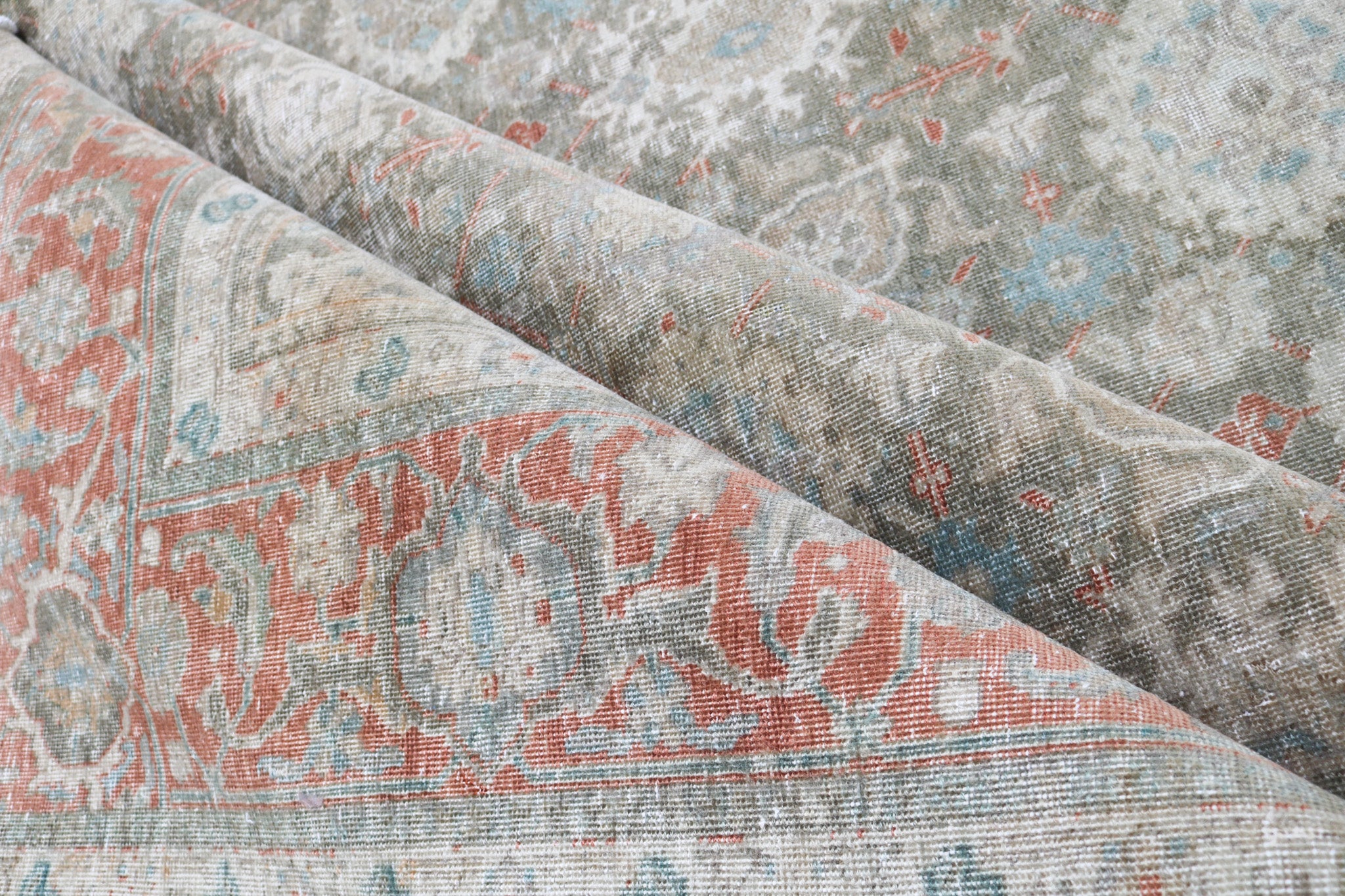 Close-up detail of antique Persian Heriz rug showing handwoven geometric motifs and natural wool colours