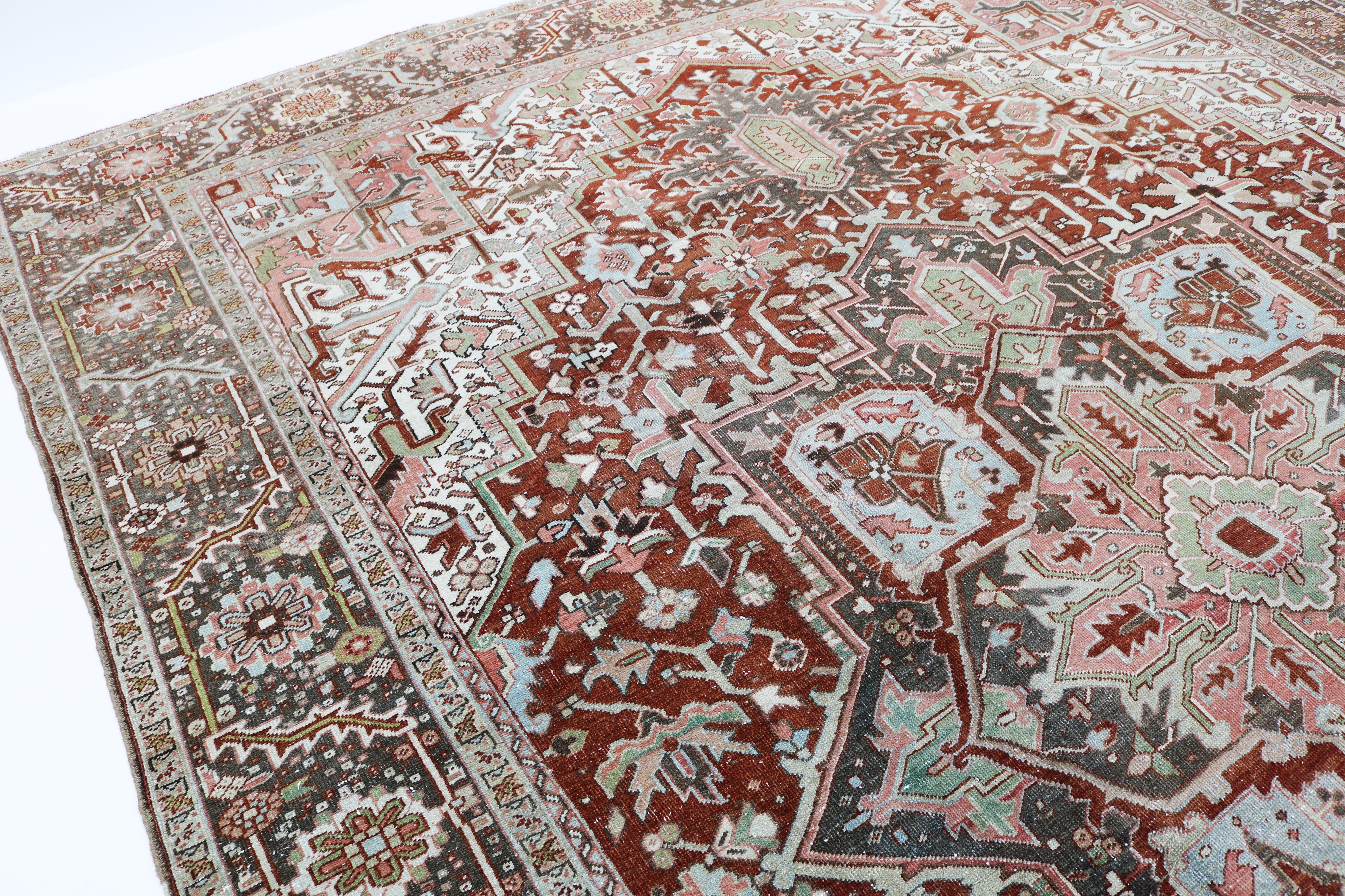 Close-up detail of antique Persian Heriz rug showing handwoven geometric motifs and natural wool colours