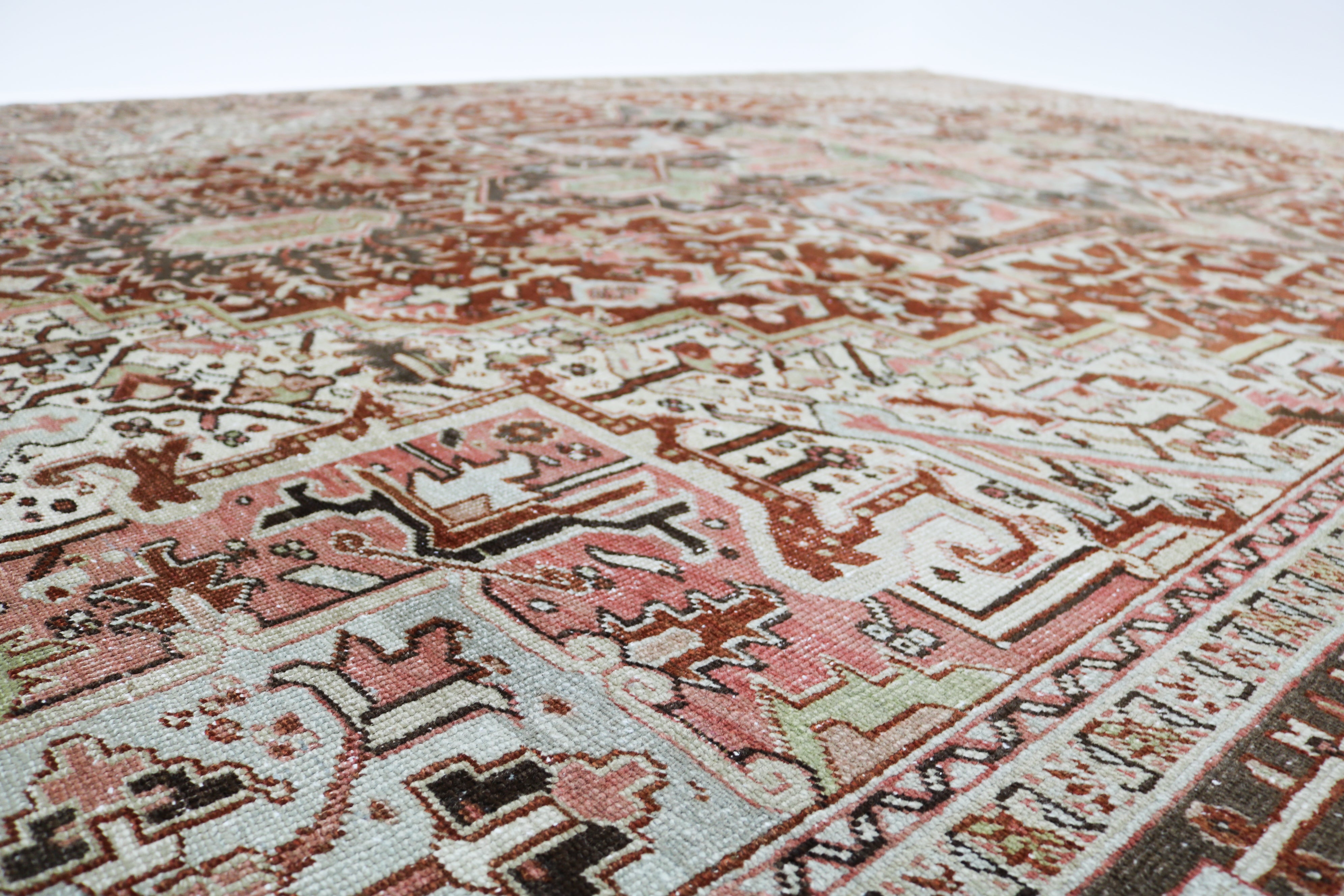 Close-up detail of antique Persian Heriz rug showing handwoven geometric motifs and natural wool colours