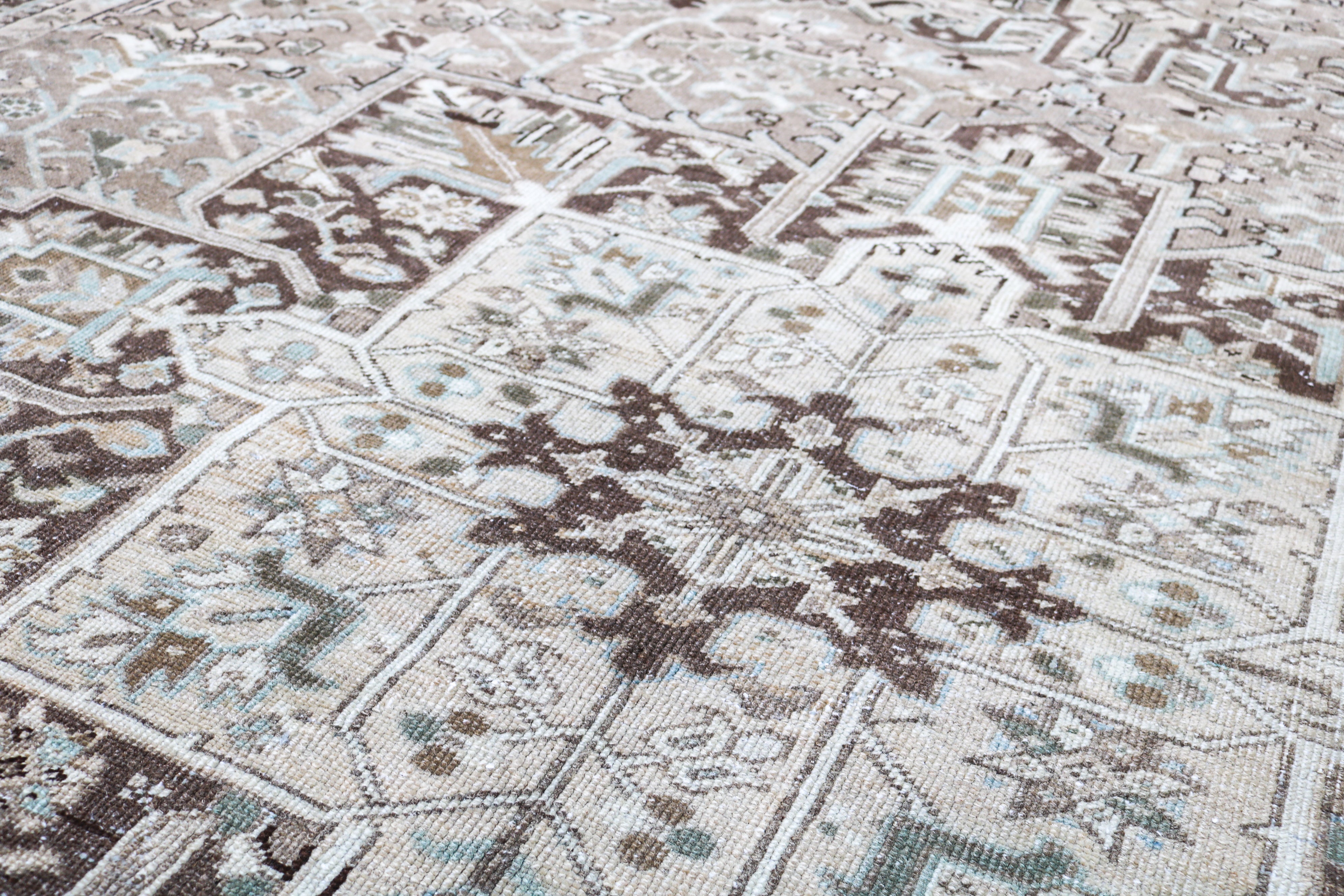 Close-up of hand-knotted Persian Heriz rug showing intricate border patterns and aged patina