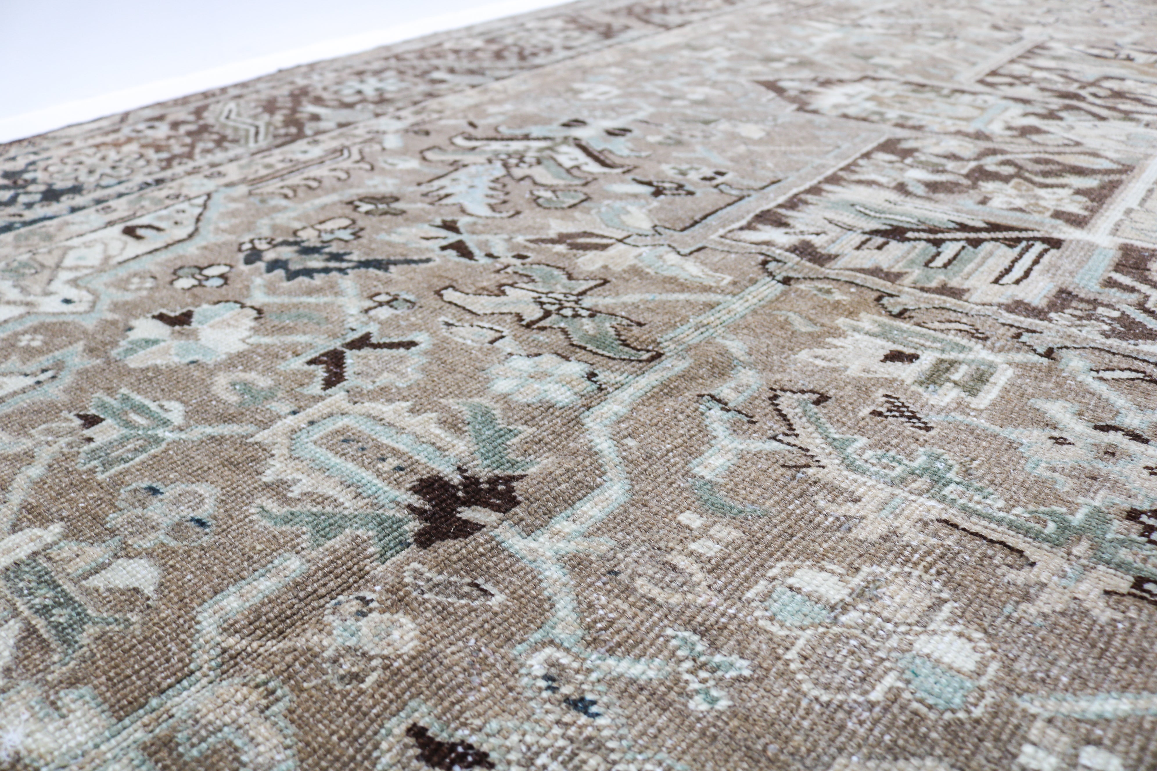 Antique Heriz carpet detail featuring traditional geometric medallion and ivory accents