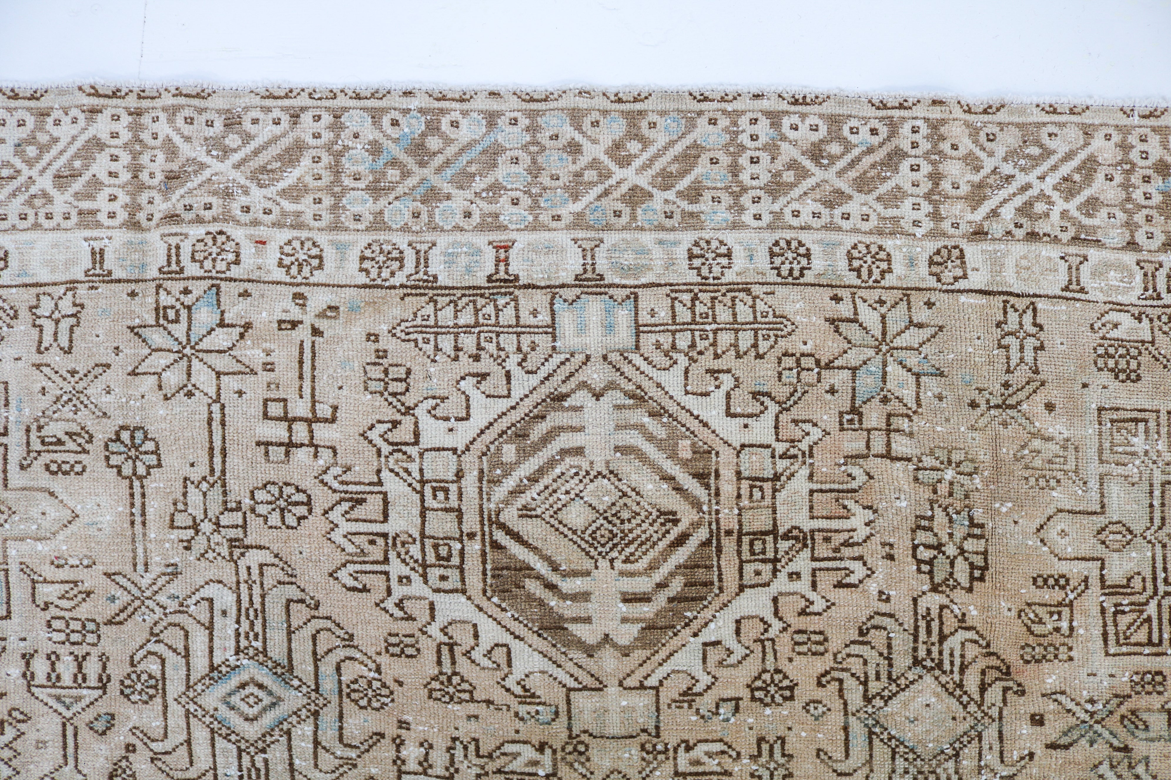 Detail of antique Persian Heriz-Karaja carpet with intricate tribal motifs and naturally faded tones
