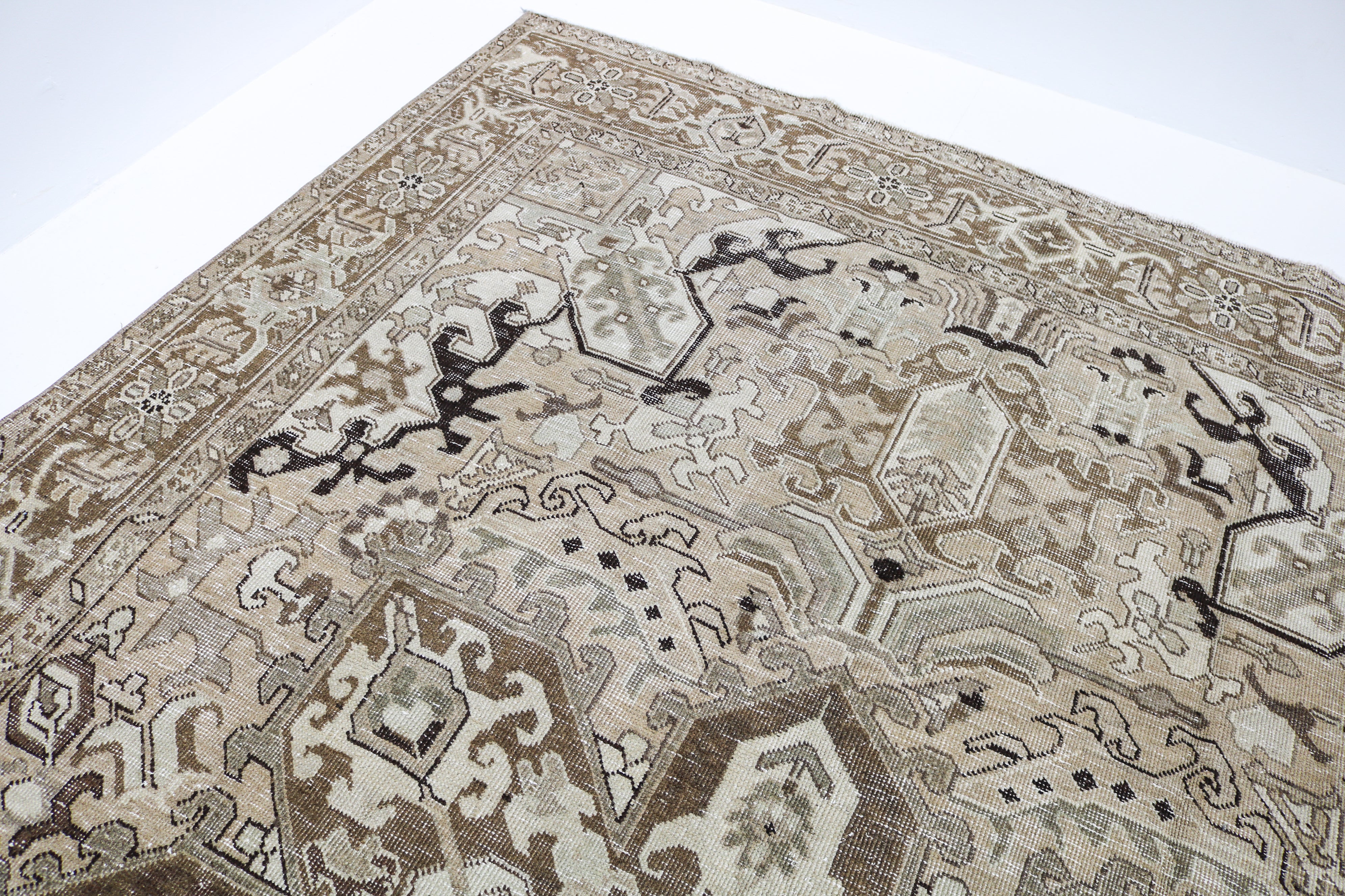 Close-up detail of vintage Persian carpet showing handwoven tribal motifs and aged wool colours