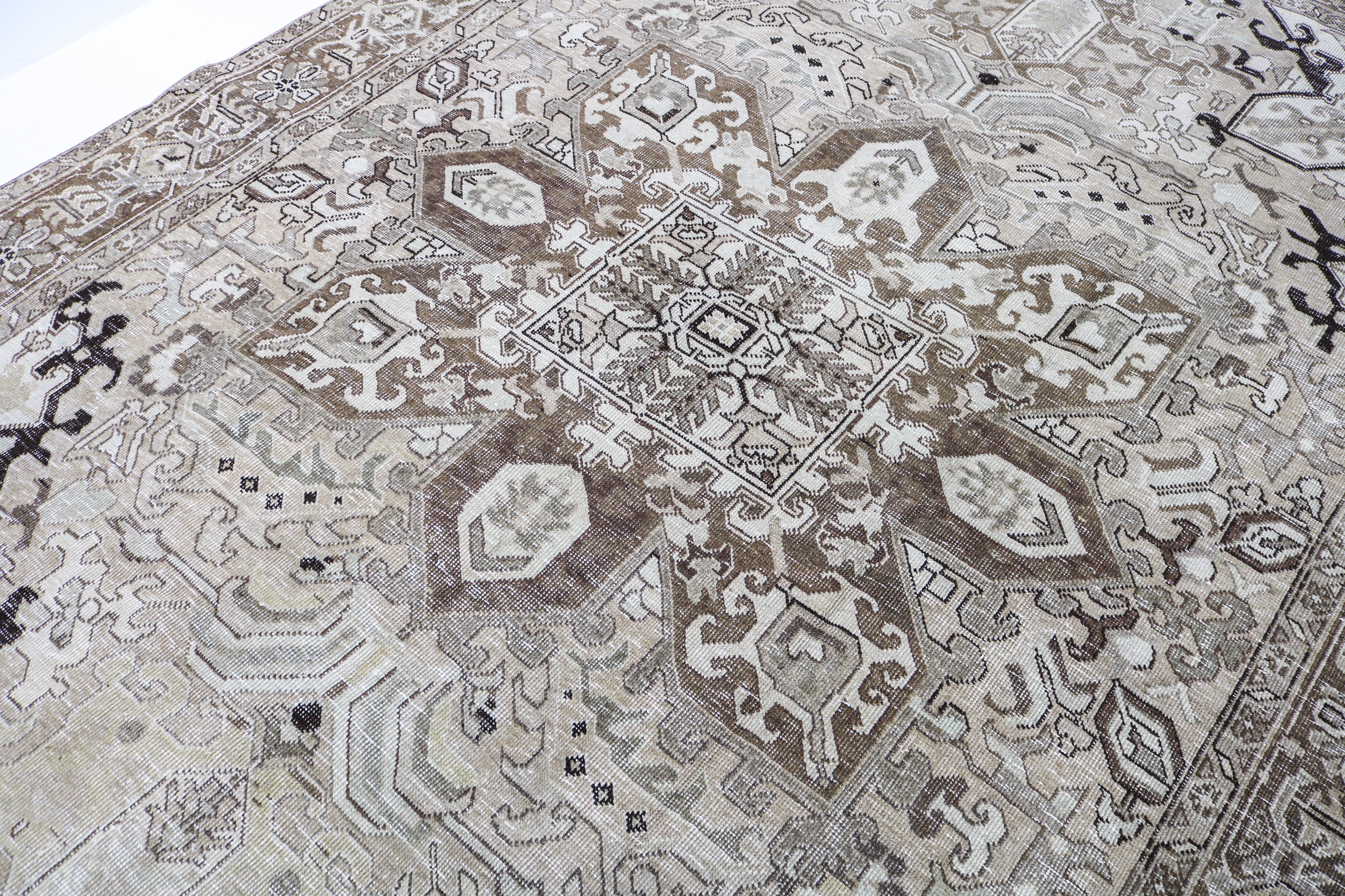 Detail of vintage Persian carpet with geometric tribal motifs and naturally faded tones