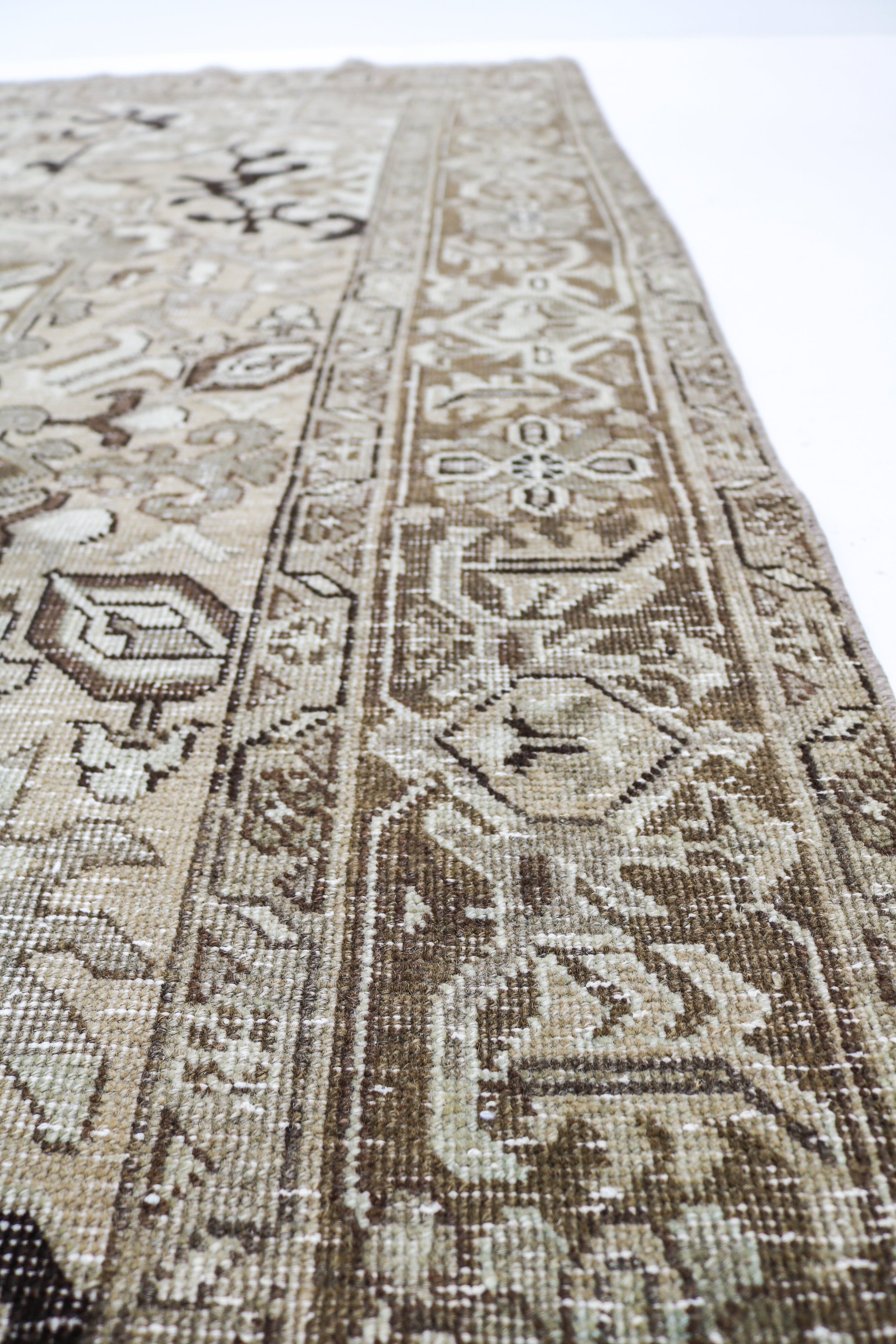 Vintage Persian rug close-up showing fine geometric weaving and subtle natural colour variation