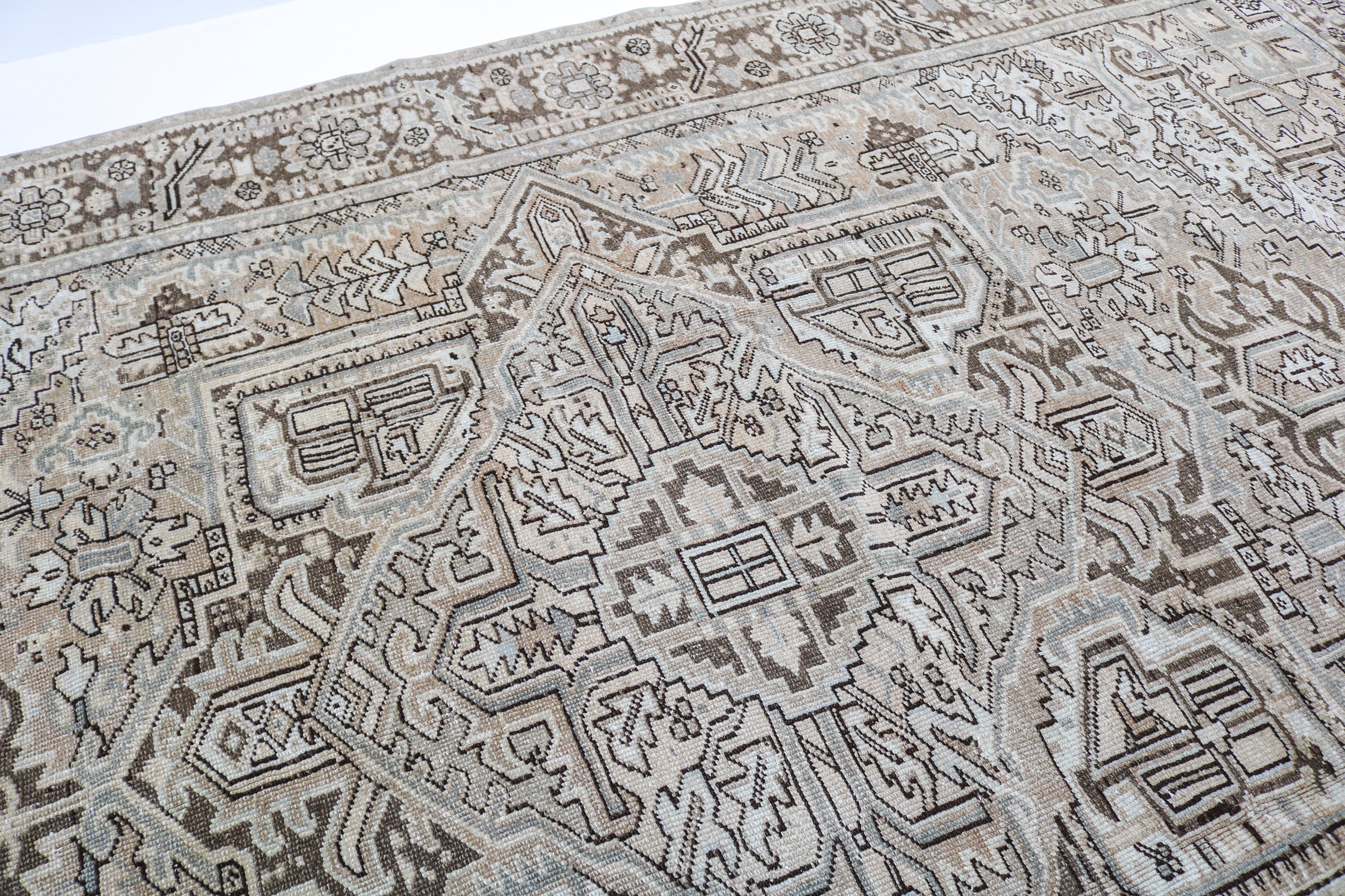 Antique Heriz carpet detail featuring traditional geometric medallion and ivory accents