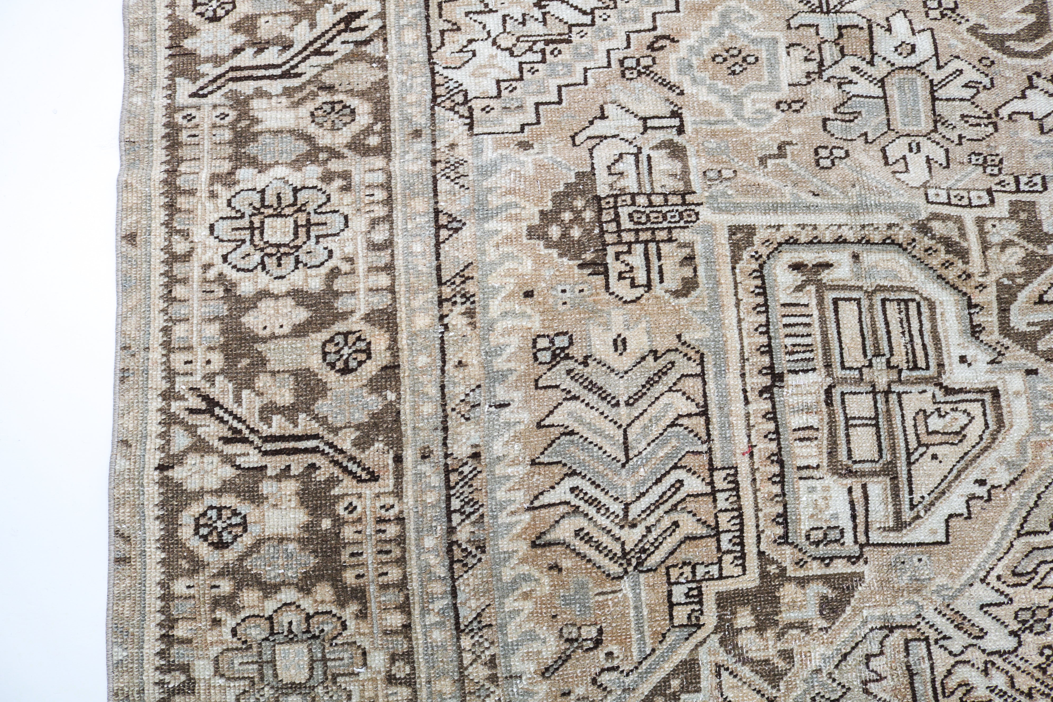 Antique Persian carpet close-up showing fine geometric weaving and subtle natural colour variation