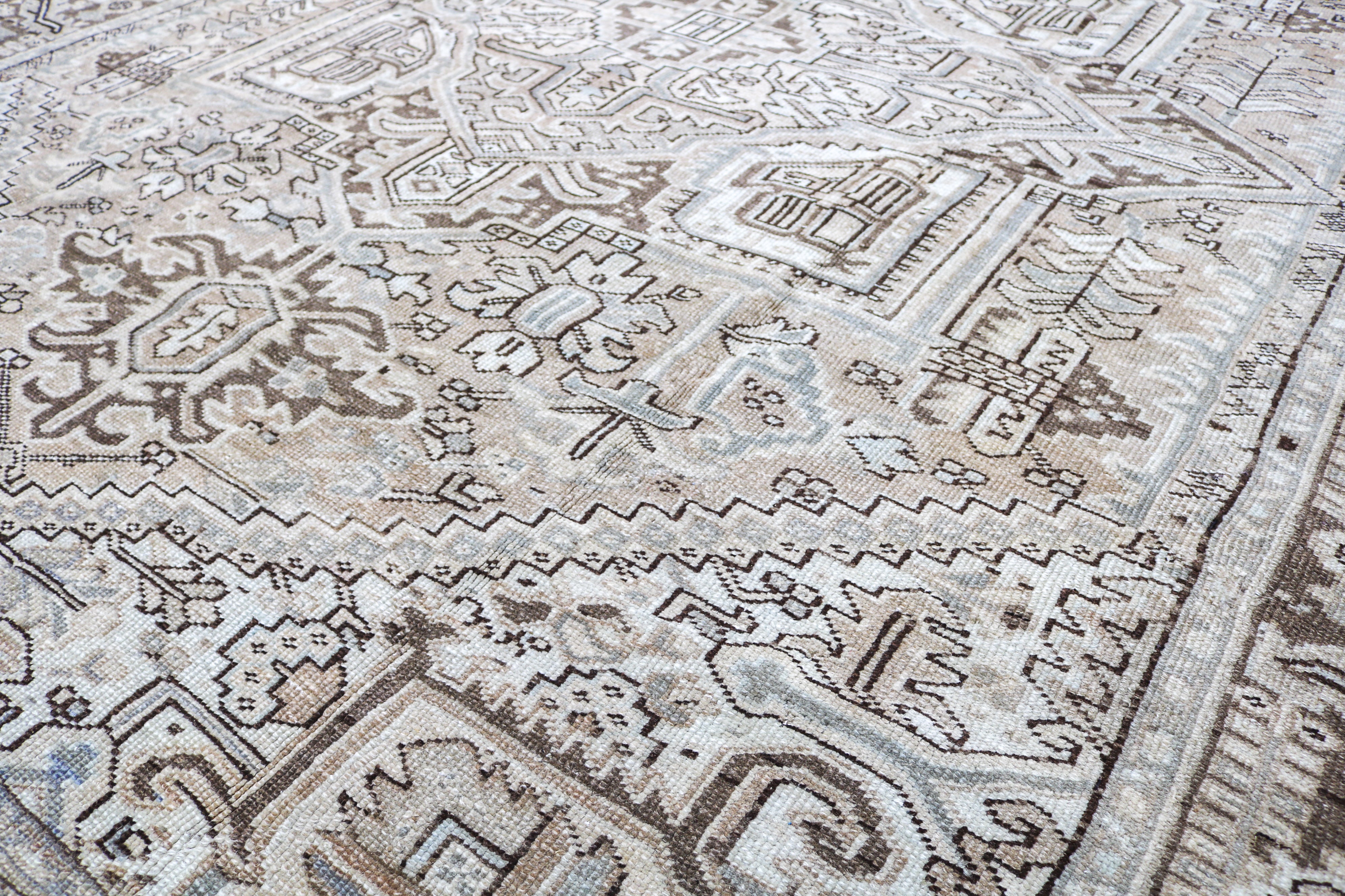 Close-up detail of antique Persian Heriz rug showing handwoven geometric motifs and aged wool colours