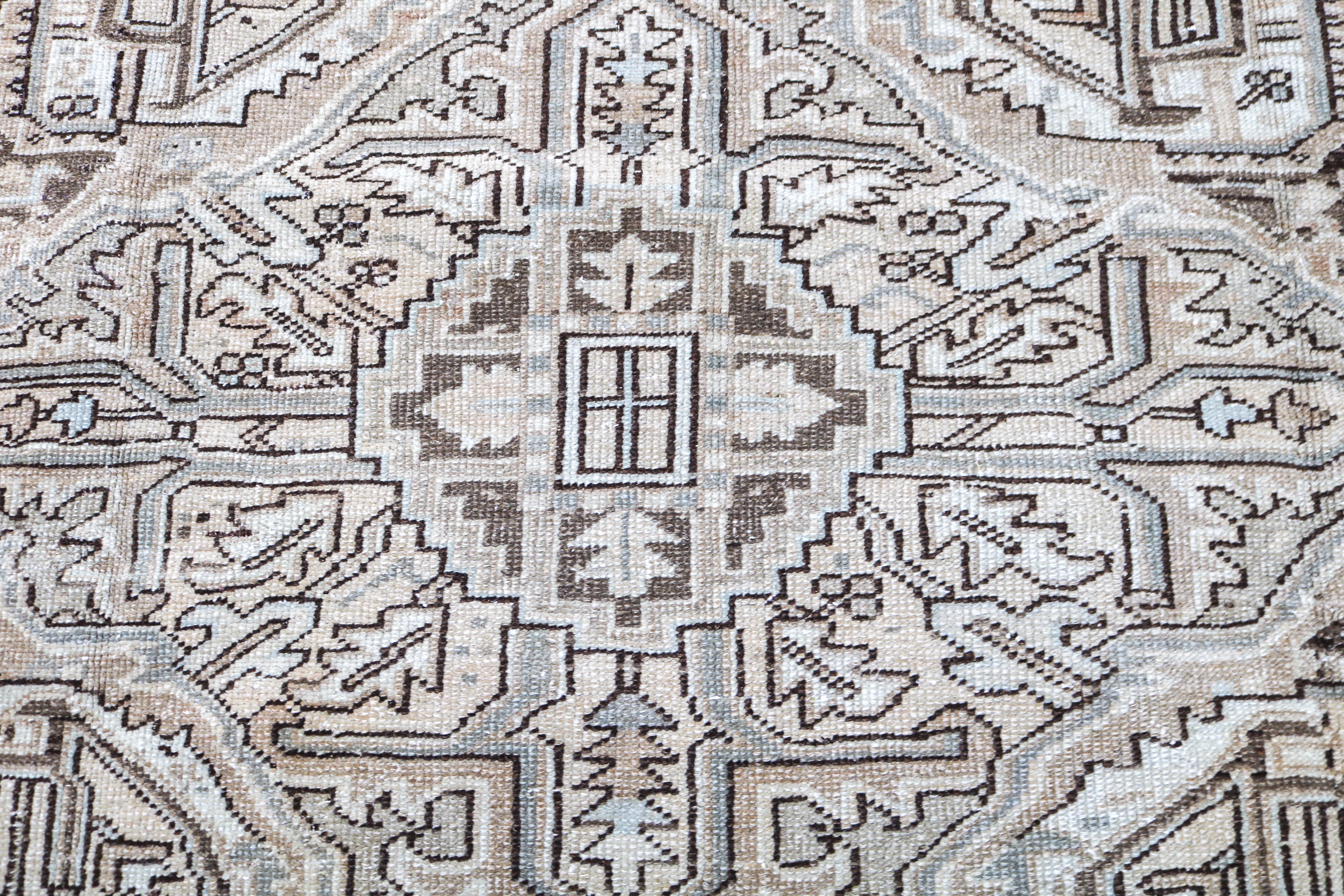 Antique Persian carpet close-up showing fine geometric weaving and subtle natural colour variation