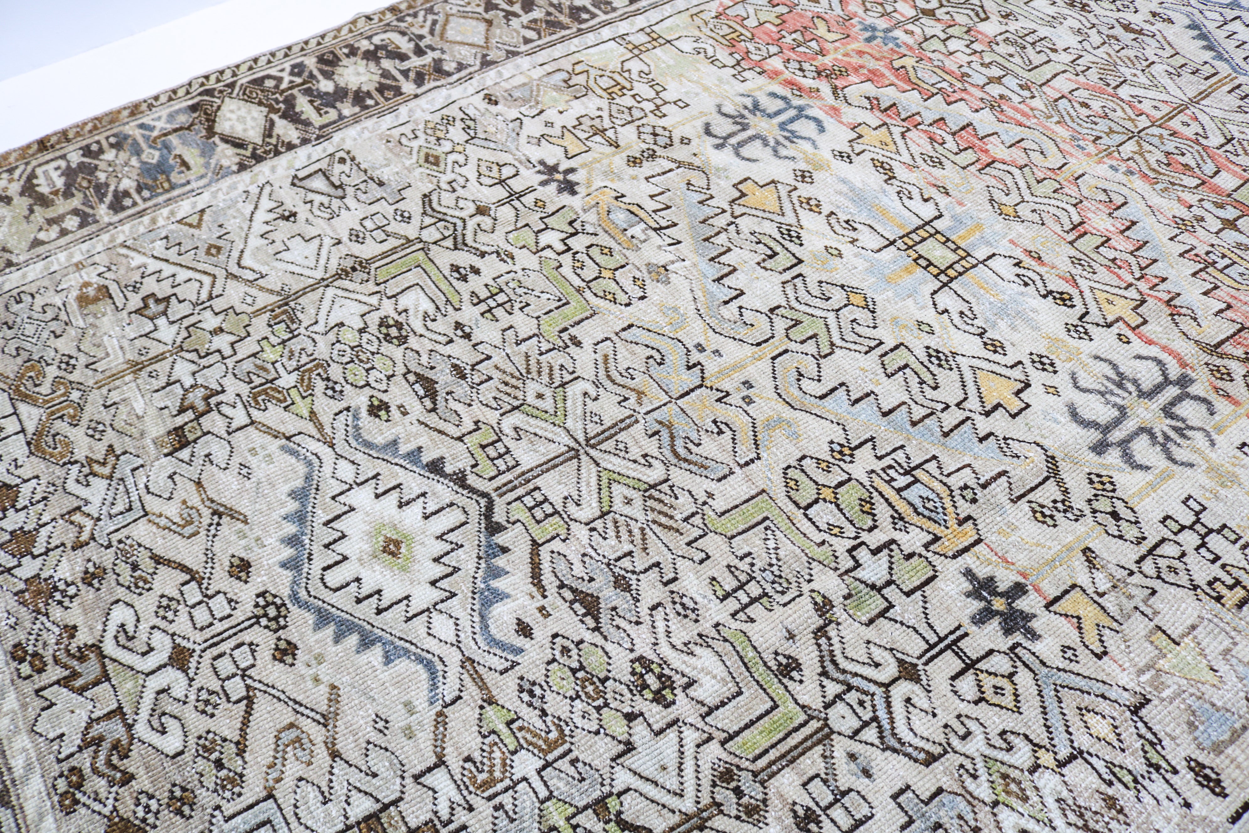 Antique Persian carpet close-up showing fine geometric weaving and subtle natural colour variation