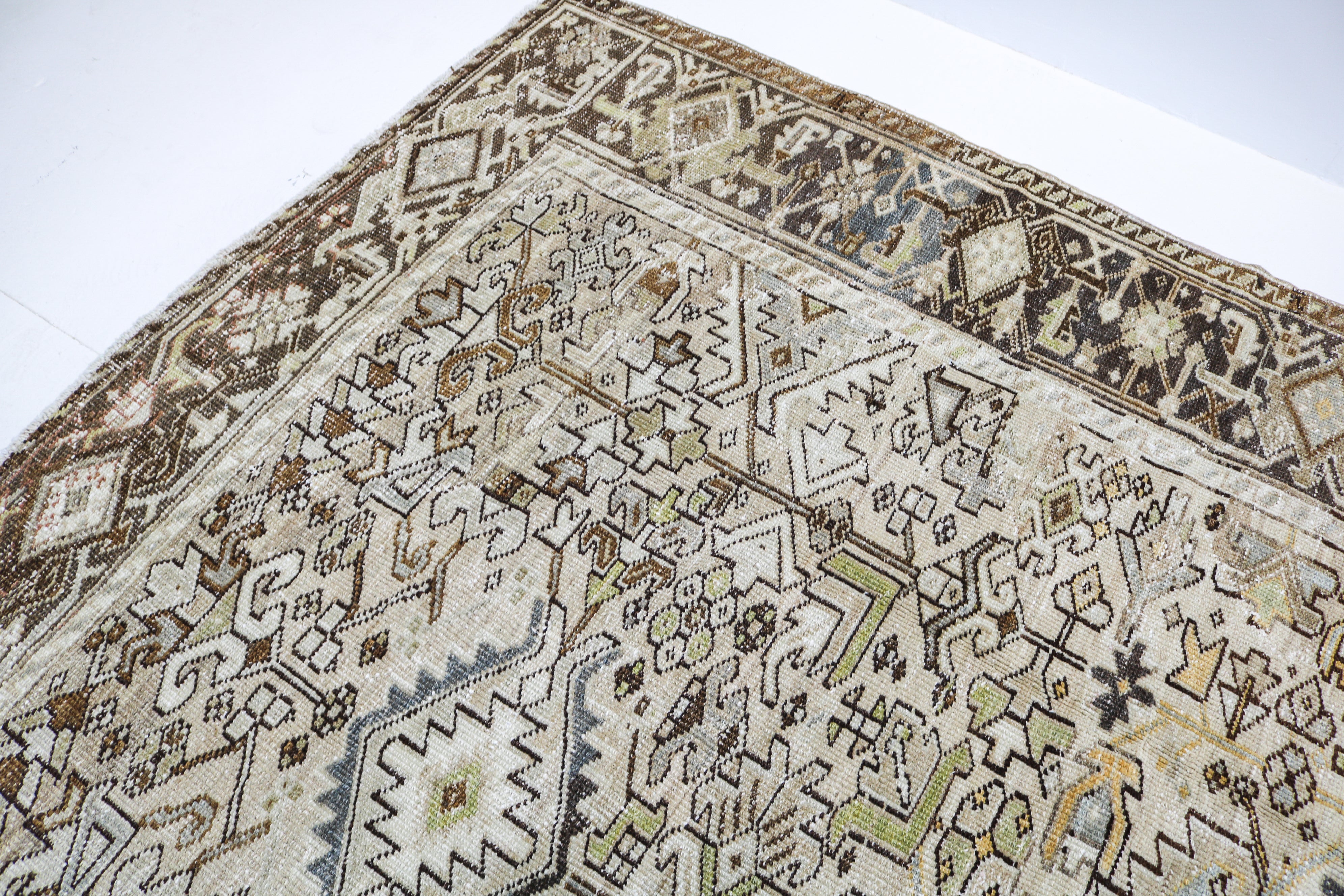 Antique Persian carpet close-up showing fine geometric weaving and subtle natural colour variation