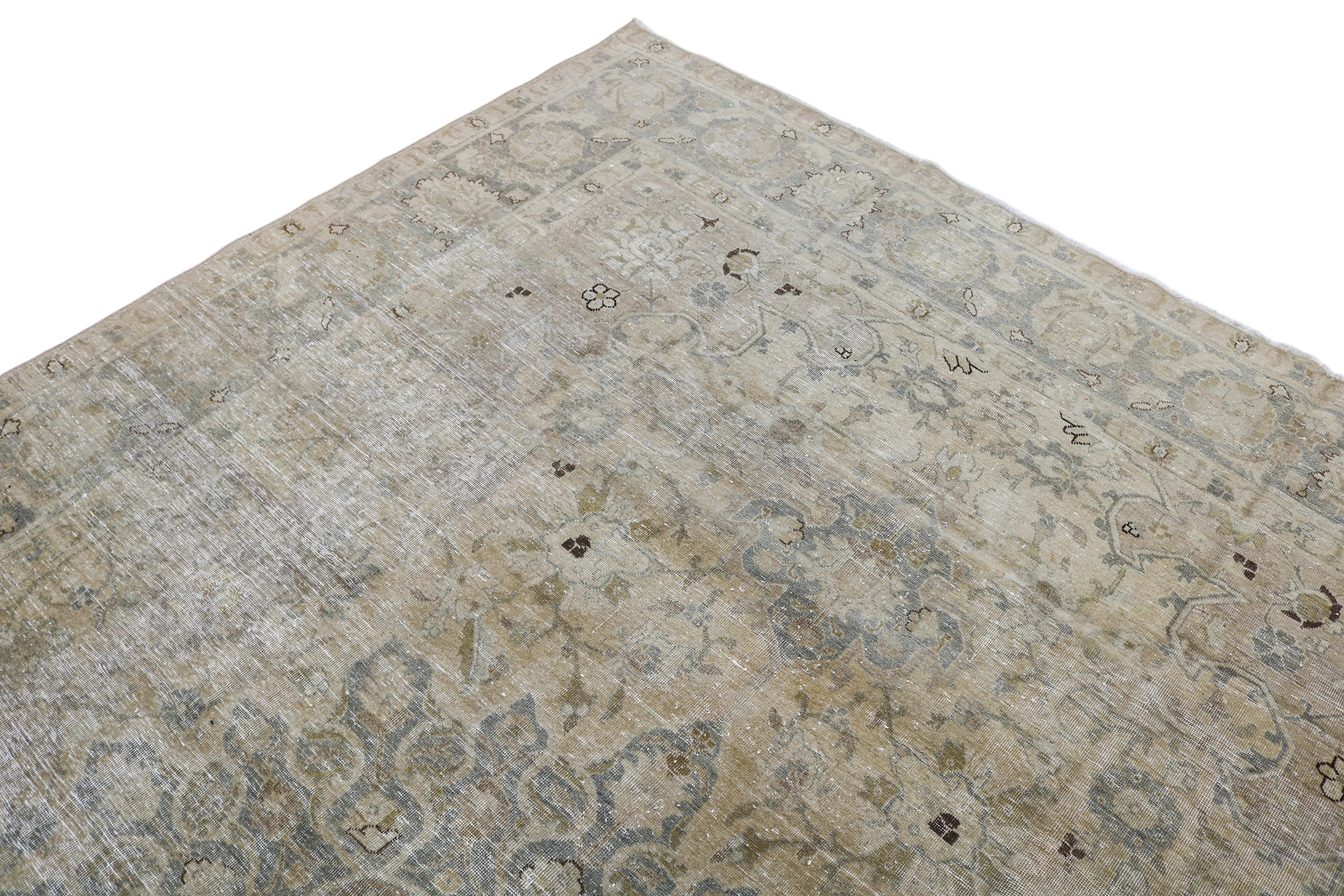 Close-up detail of antique Persian Tabriz rug showing handwoven floral motifs and aged wool colours