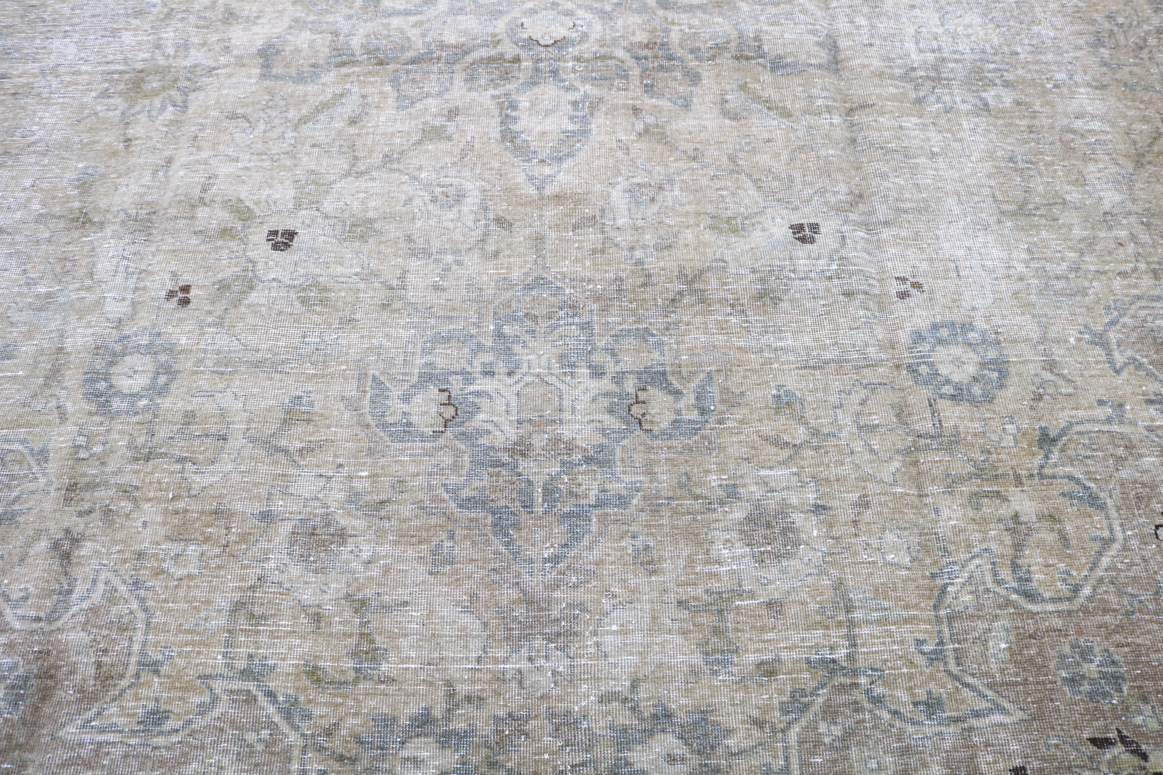 Detail of antique Persian Tabriz carpet with refined floral motifs and softly faded natural tones