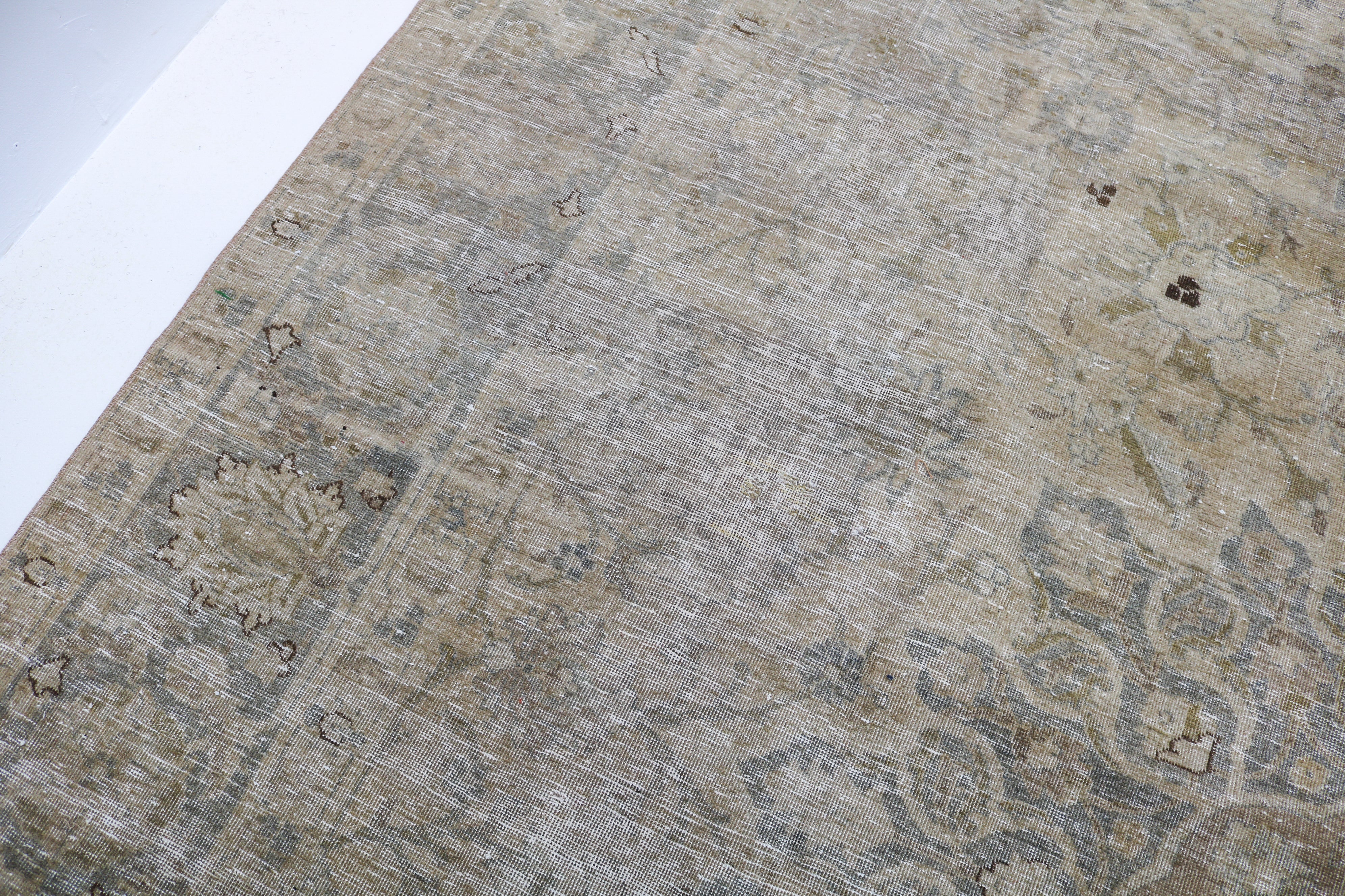 Antique Tabriz carpet detail featuring elegant floral design and subtle ivory accents