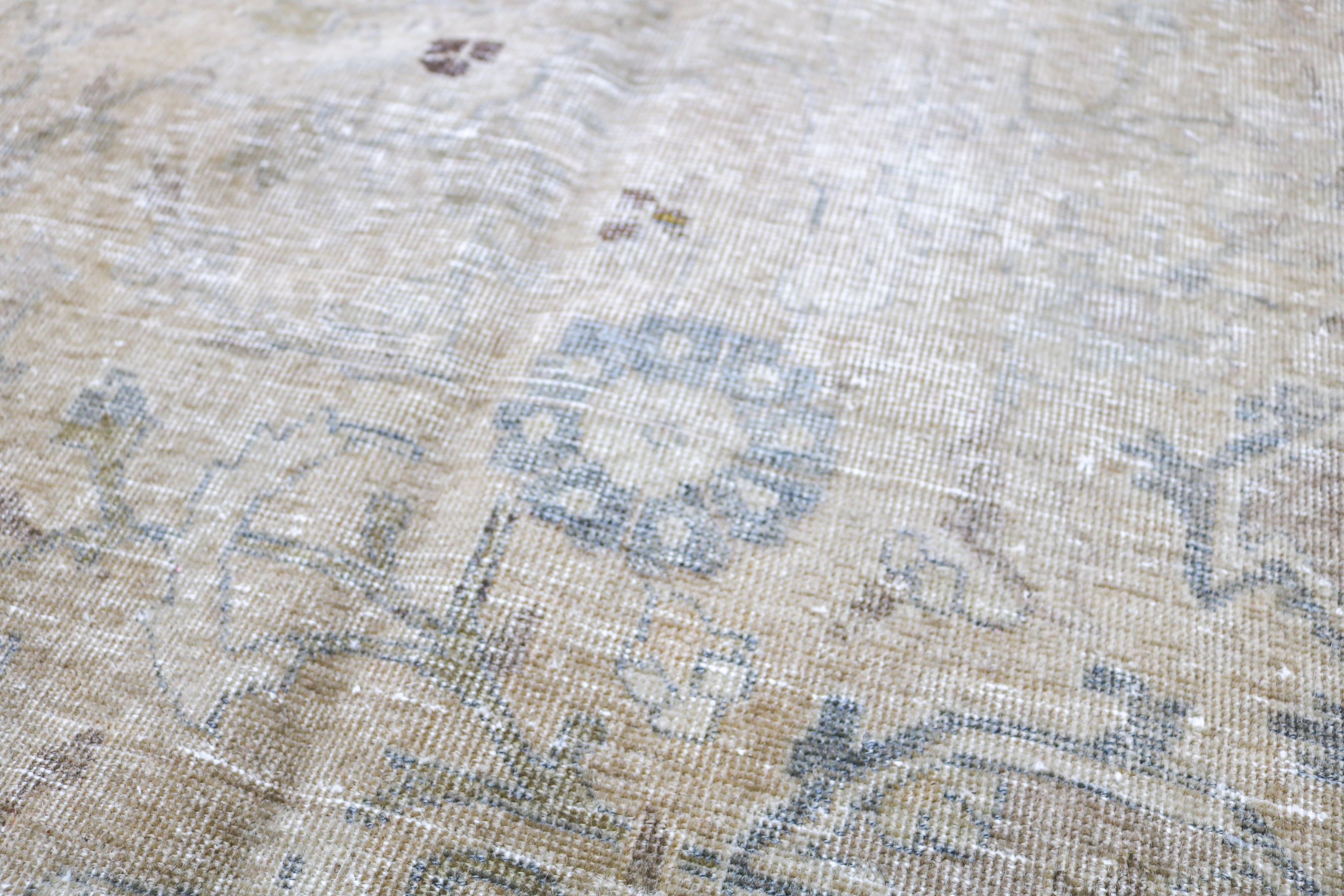 Antique Persian carpet close-up showing fine floral weaving and subtle natural colour variation