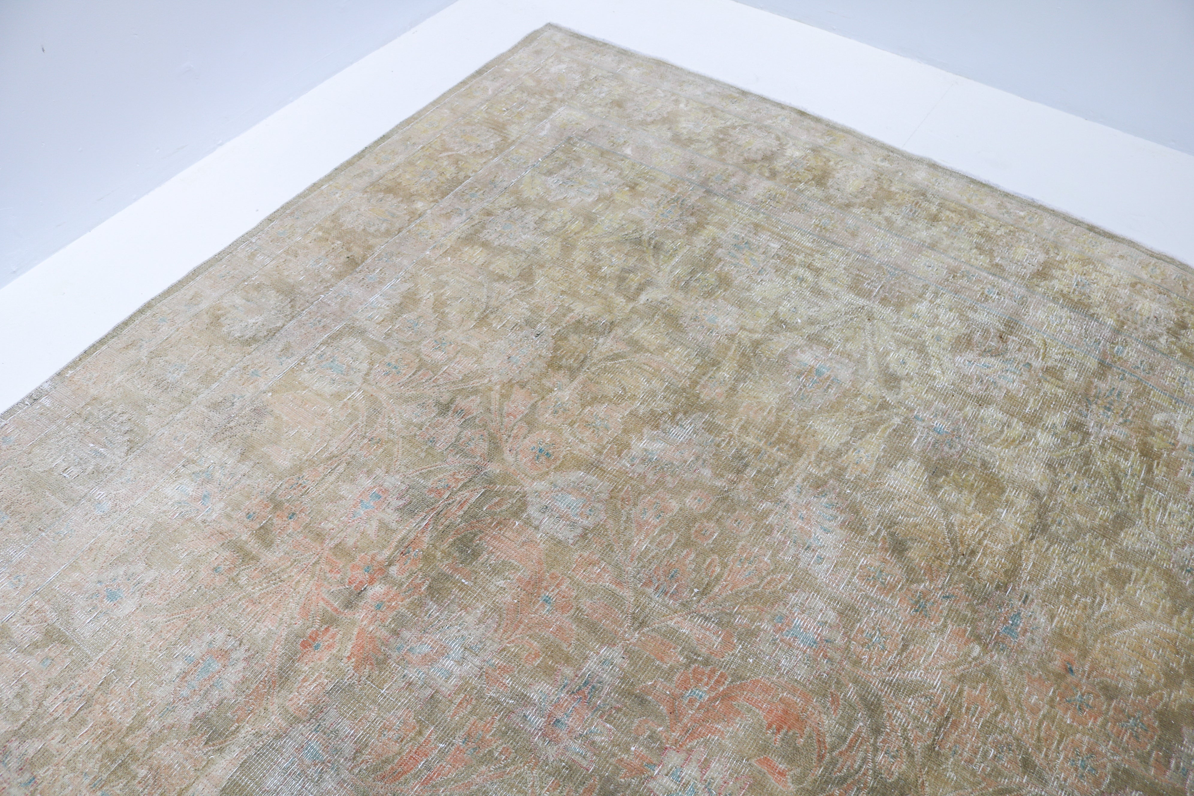 Close-up detail of vintage Persian Sarouk rug showing handwoven floral motifs and aged wool colours