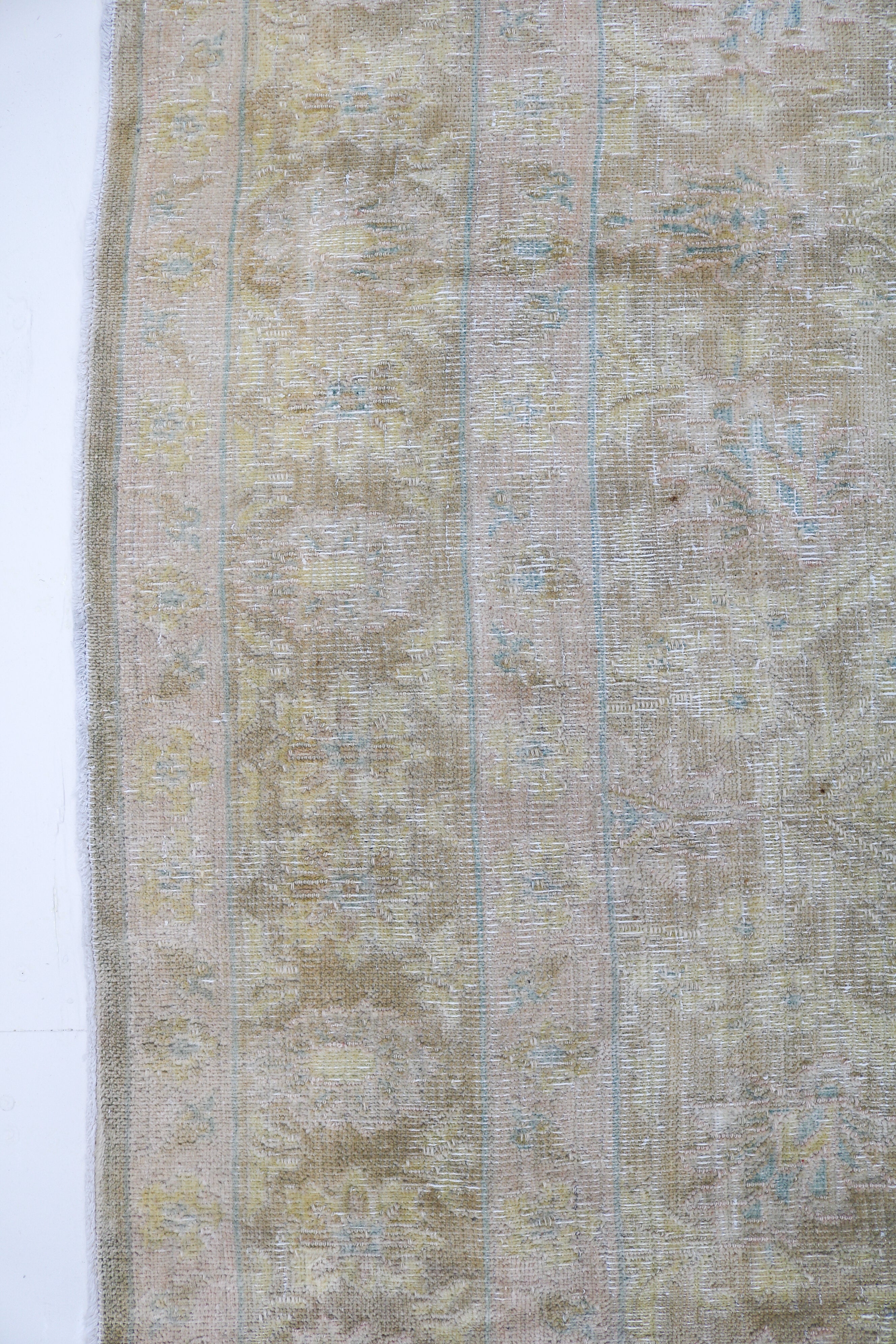Vintage Sarouk carpet detail featuring refined floral design and subtle blush accents