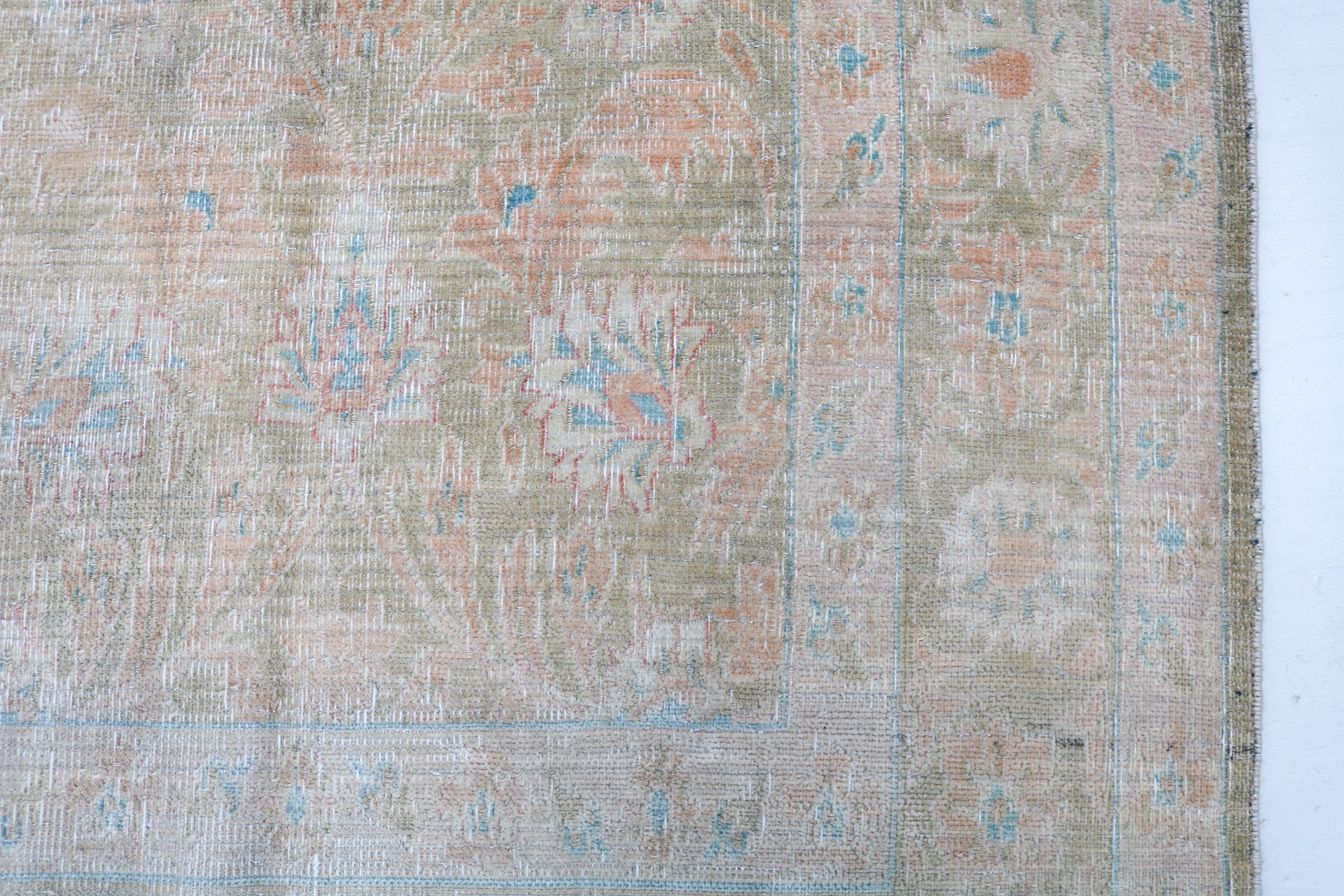 Vintage Persian carpet close-up showing fine floral weaving and subtle natural colour variation