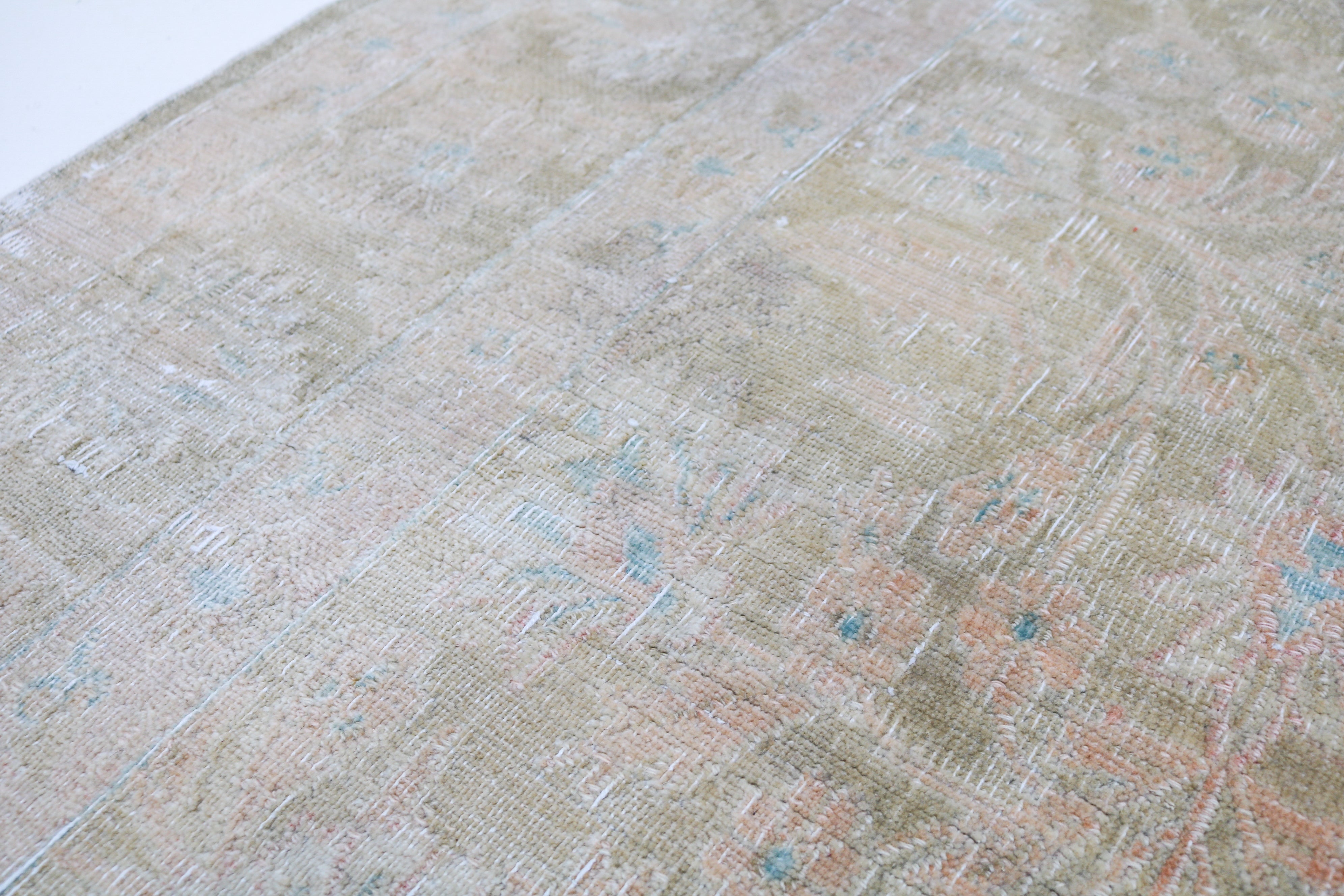 Vintage Sarouk carpet detail featuring refined floral design and subtle blush accents