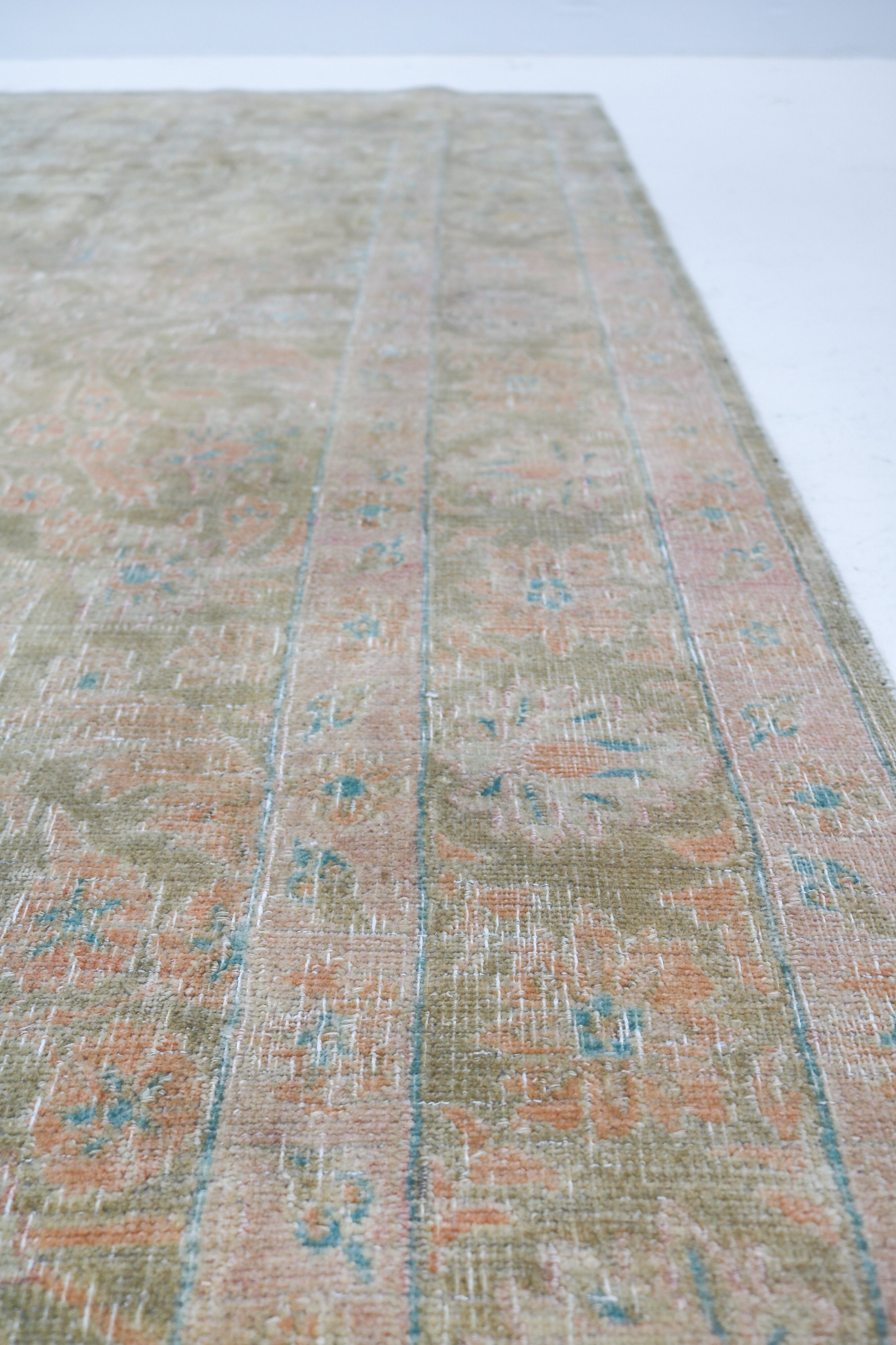 Vintage Sarouk carpet detail featuring refined floral design and subtle blush accents