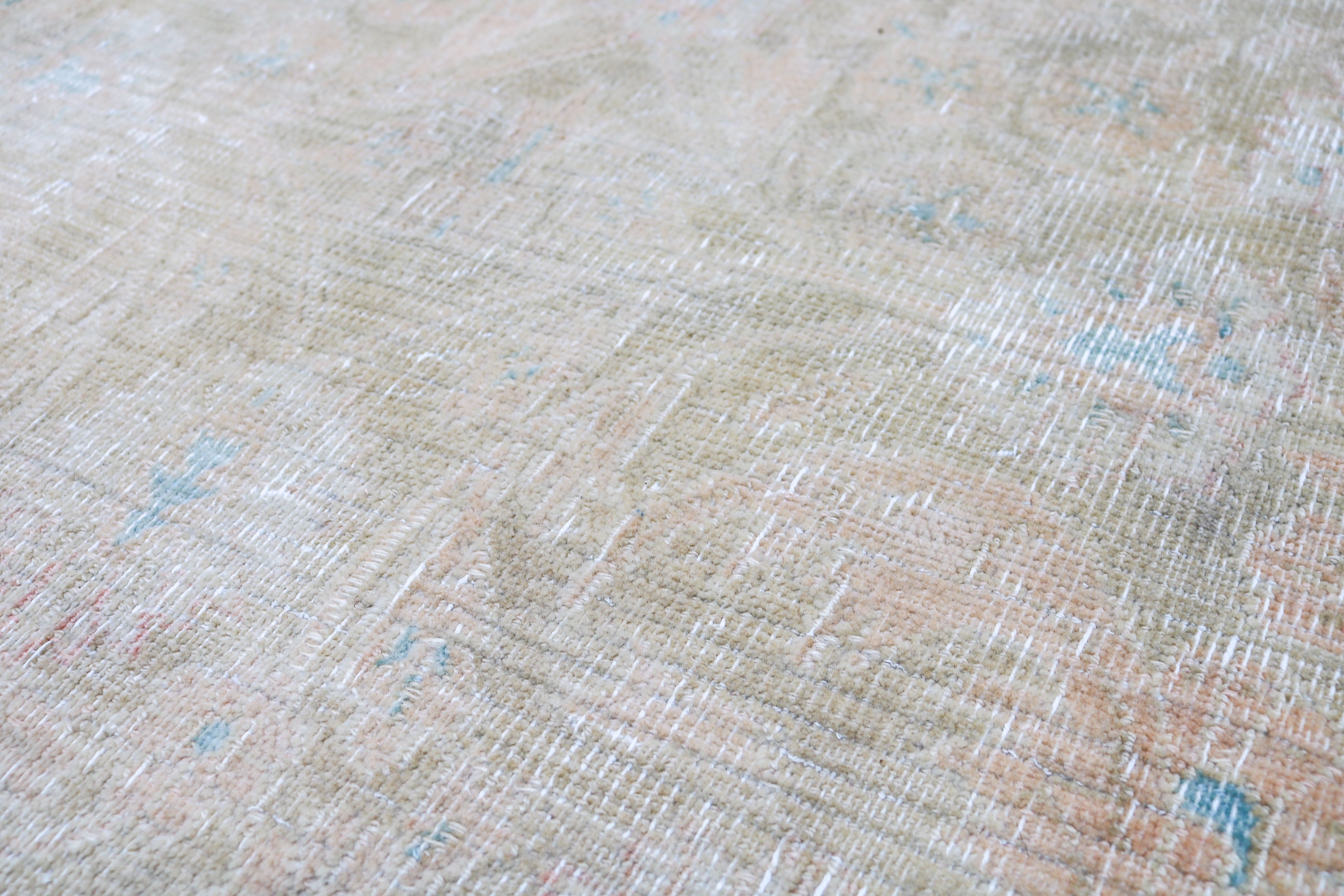 Vintage Sarouk carpet detail featuring refined floral design and subtle blush accents
