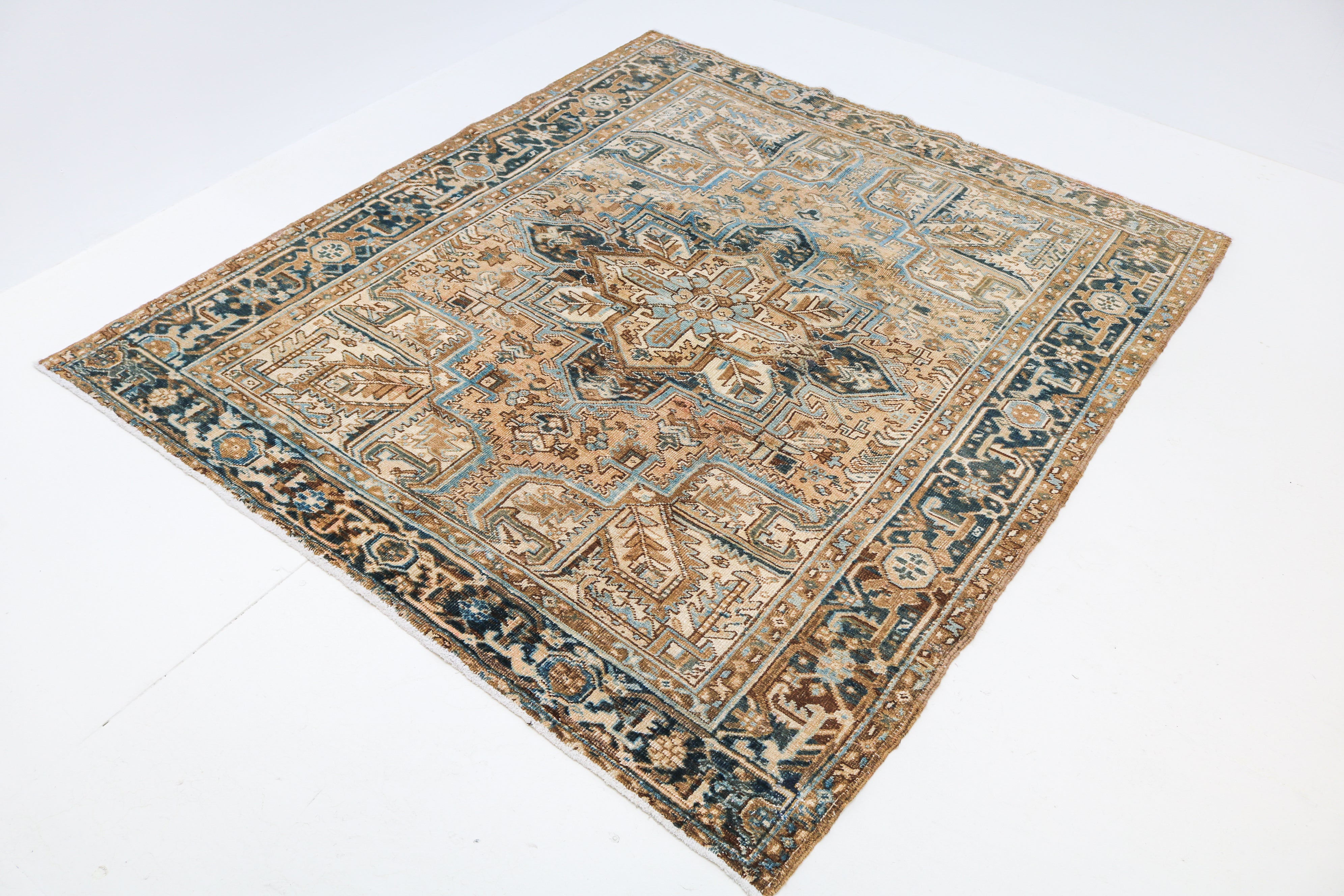 Hand-knotted antique Persian Heriz rug with bold tribal motifs and naturally aged colours