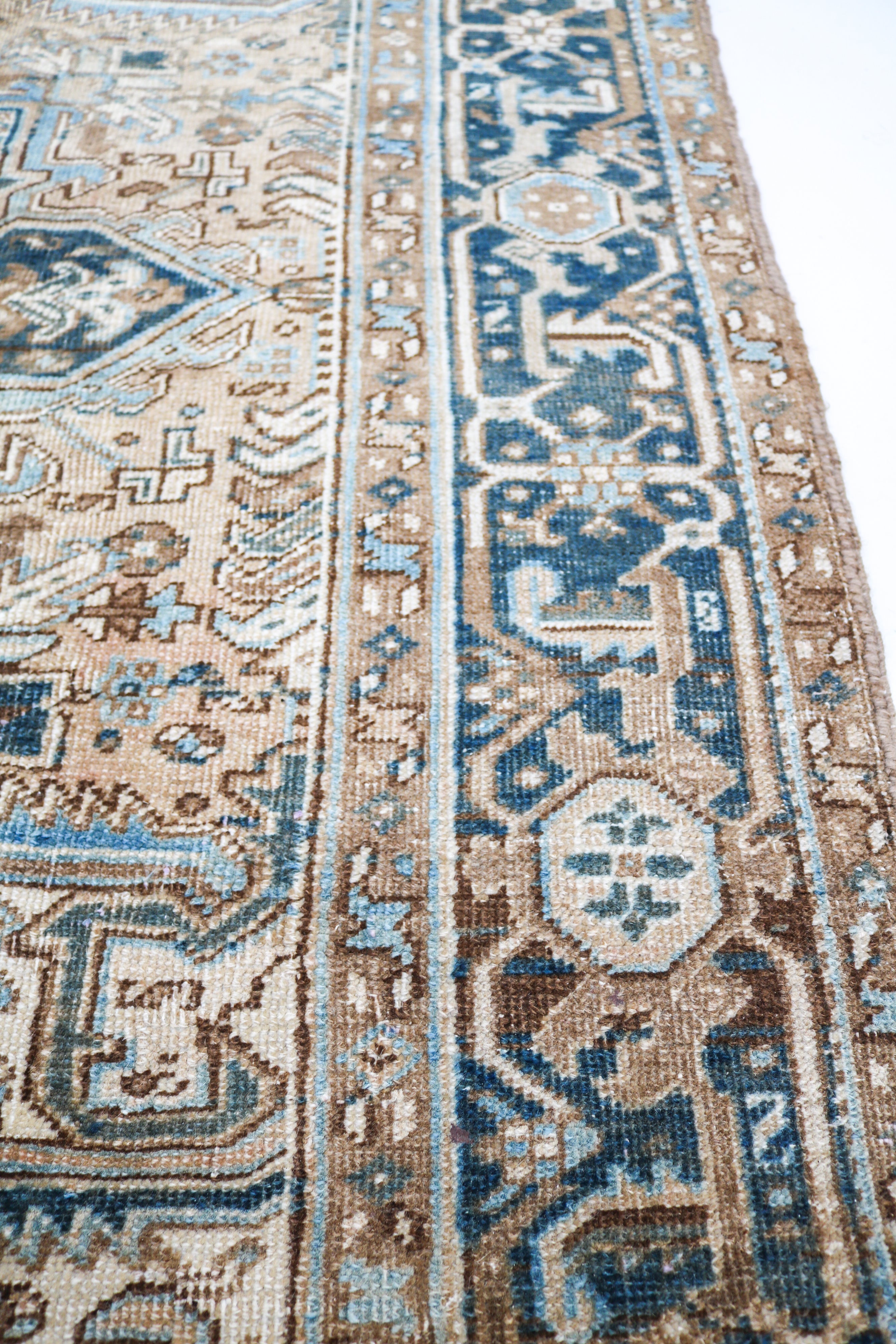 Close-up of hand-knotted Persian Heriz rug showing intricate border patterns and authentic aged patina
