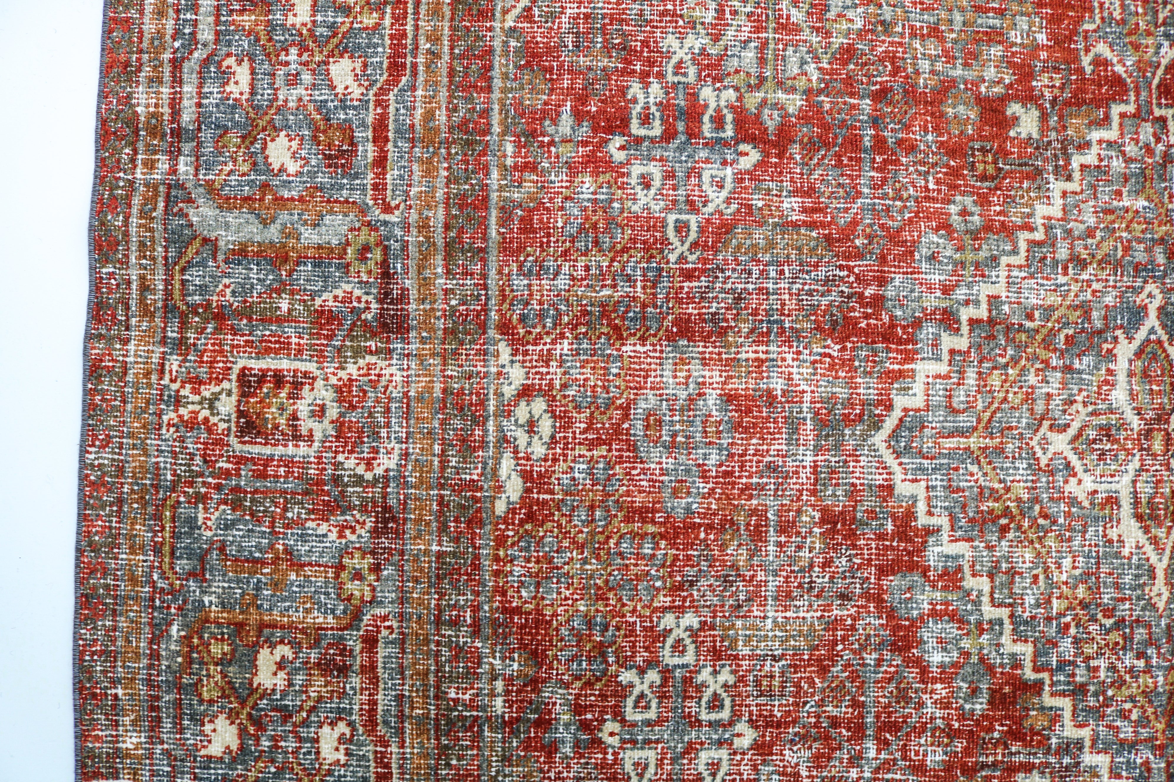Close-up detail of antique Persian Josheqan rug showing handwoven floral motifs and aged wool colours