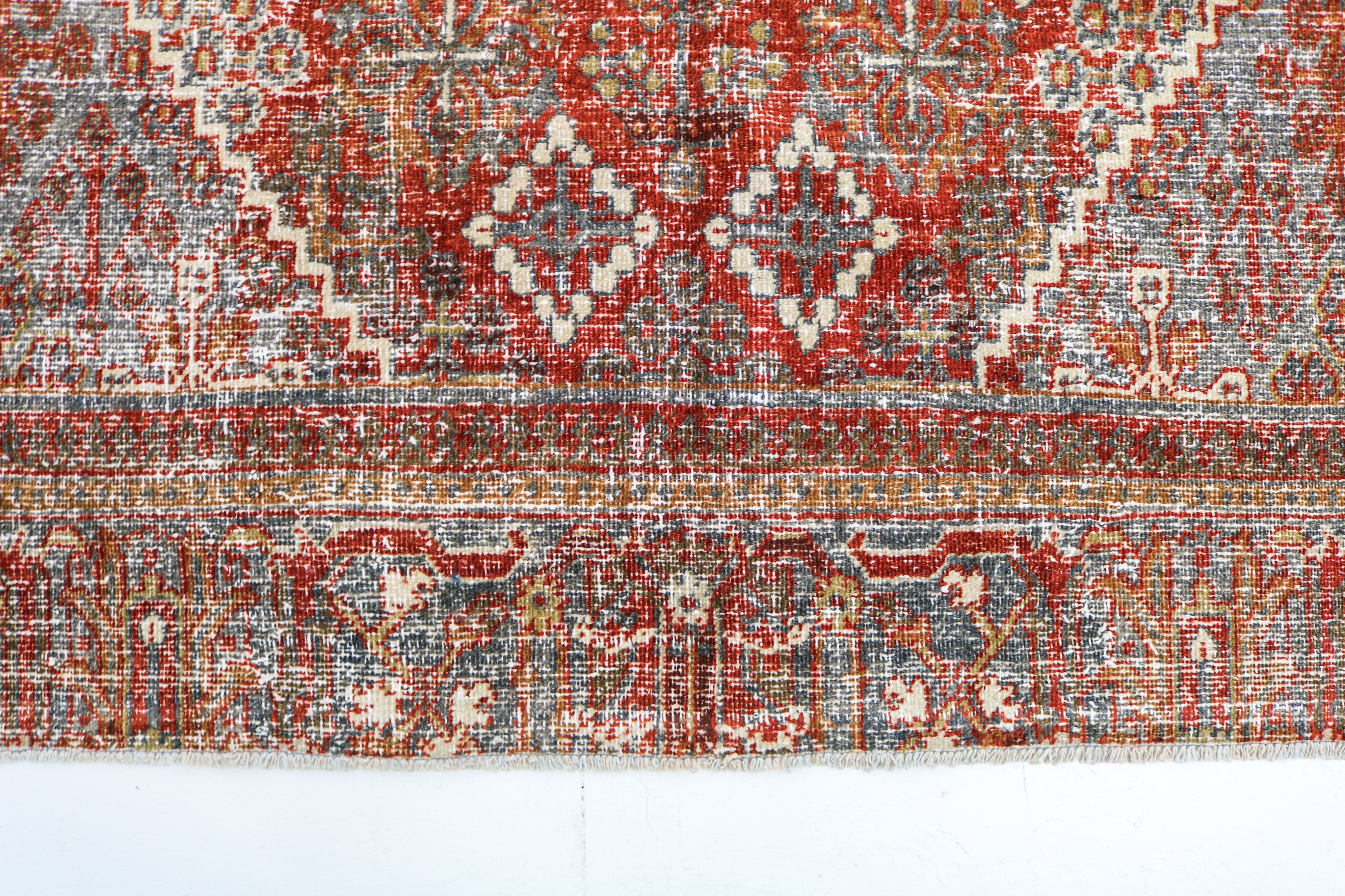 Close-up detail of antique Persian Josheqan rug showing handwoven floral motifs and aged wool colours