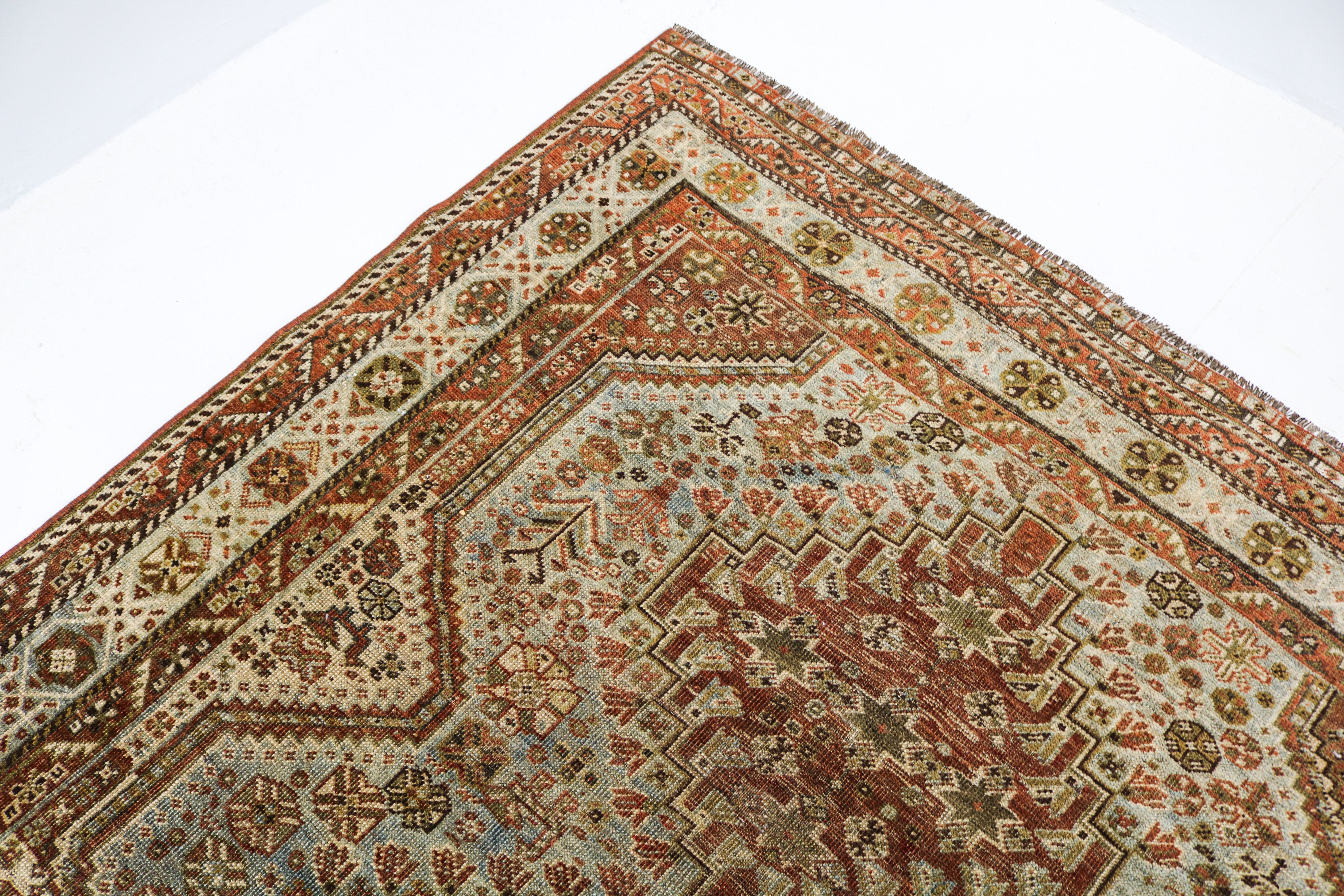 Antique Persian Qashqai rug circa 1920 displayed with traditional tribal medallion design