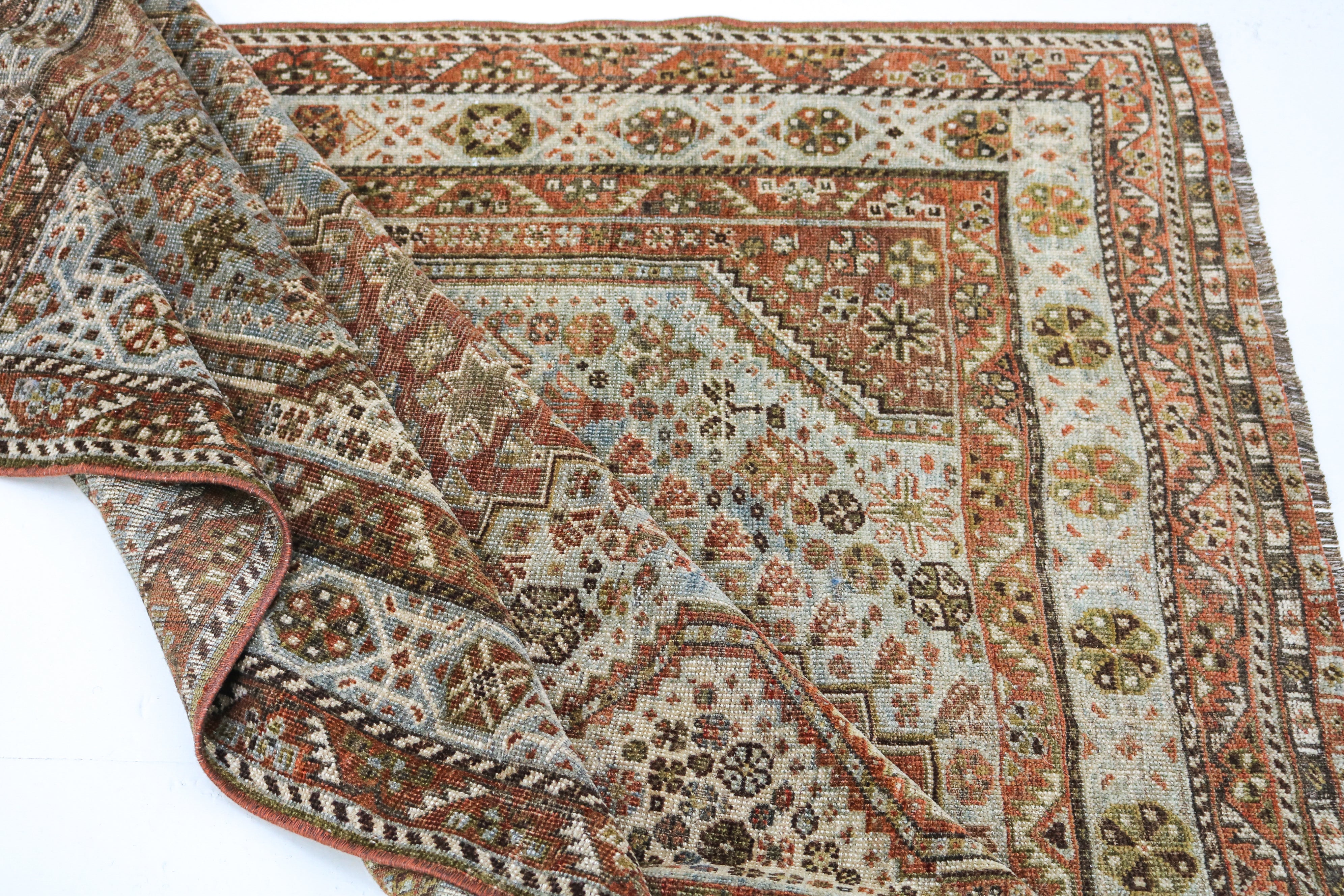 Antique Persian rug close-up showing fine tribal weaving and subtle natural colour variation