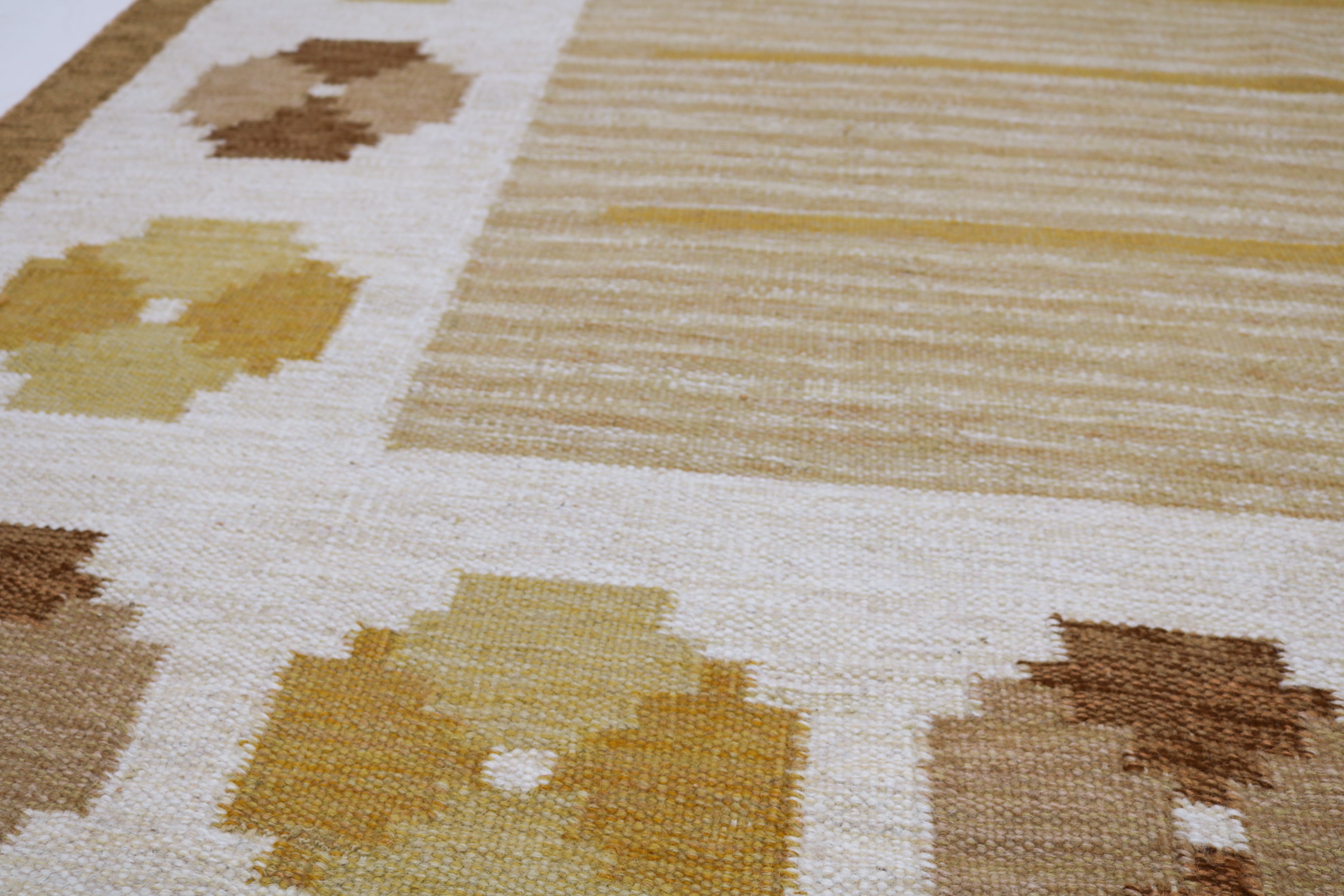 Detail of vintage Swedish kilim rug with mustard and brown geometric motifs