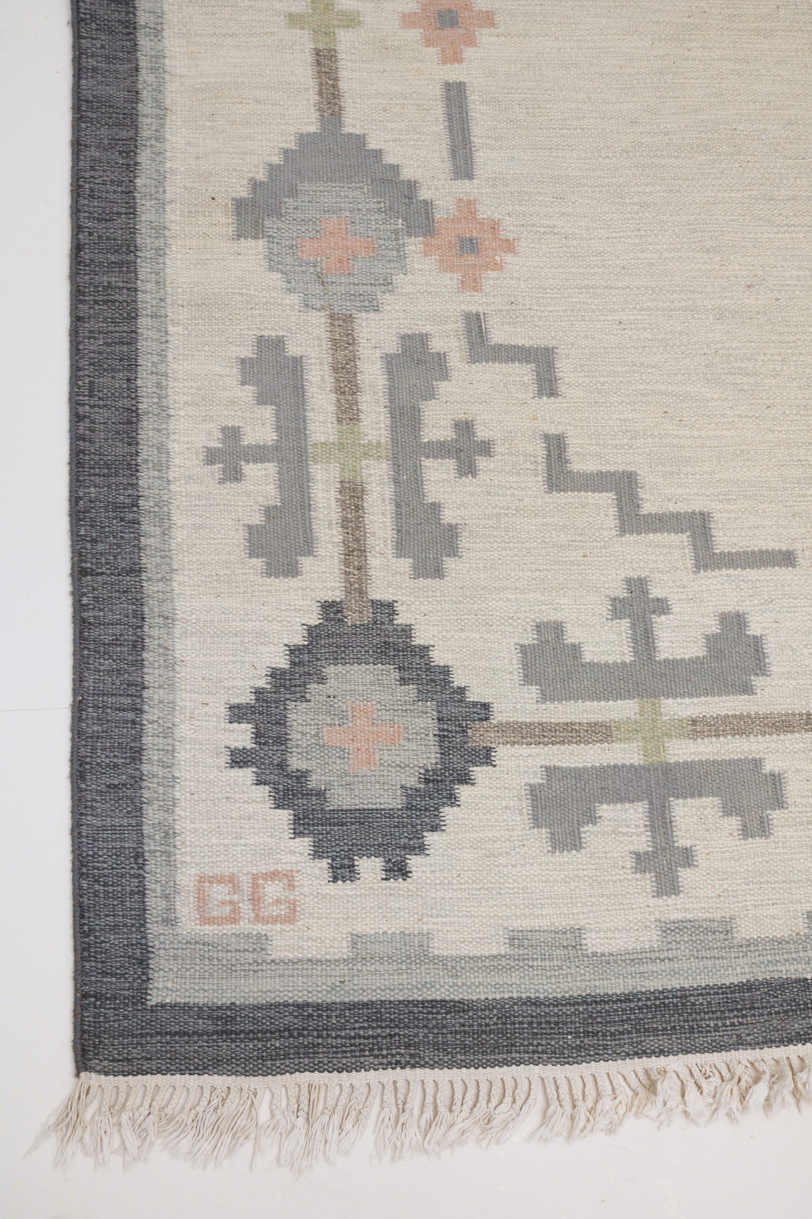 Close-up of vintage Swedish kilim rug with grey and peach geometric motifs