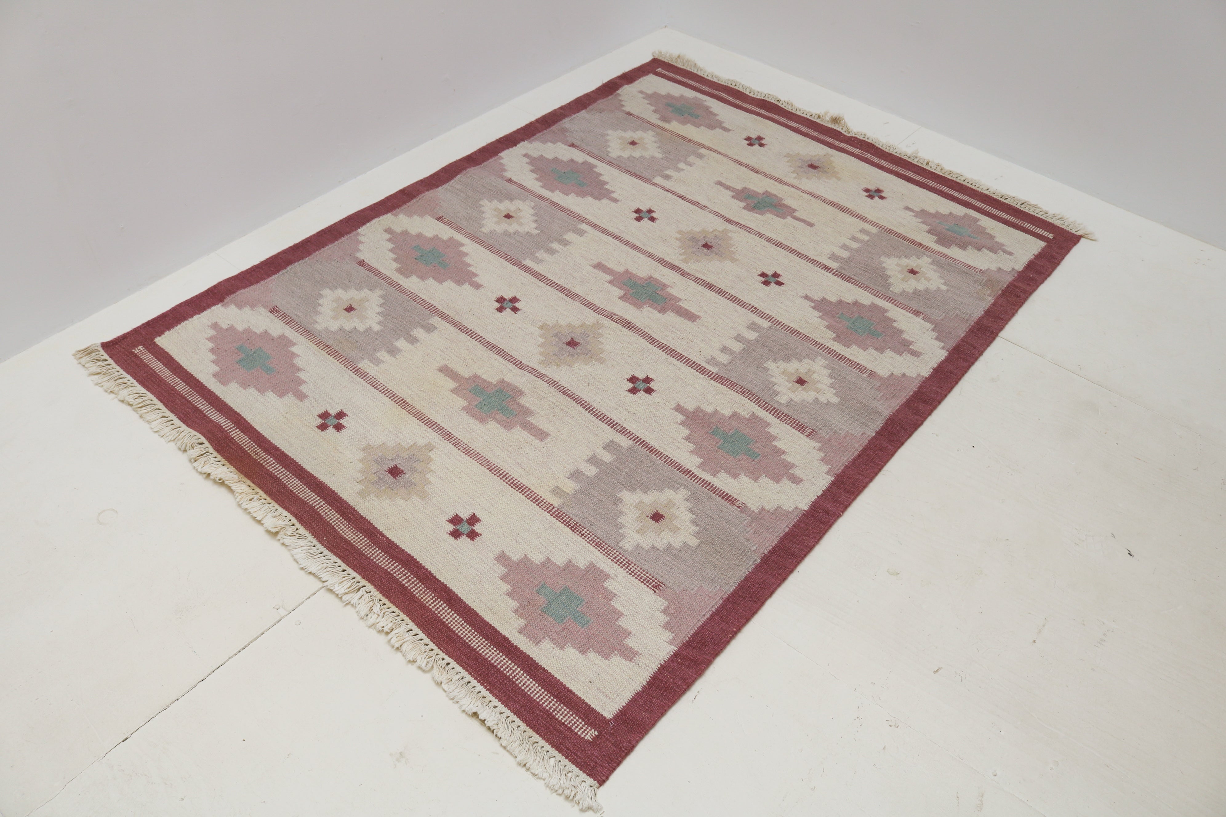 Close-up detail of handwoven wool and geometric motifs on vintage Swedish Kilim rug