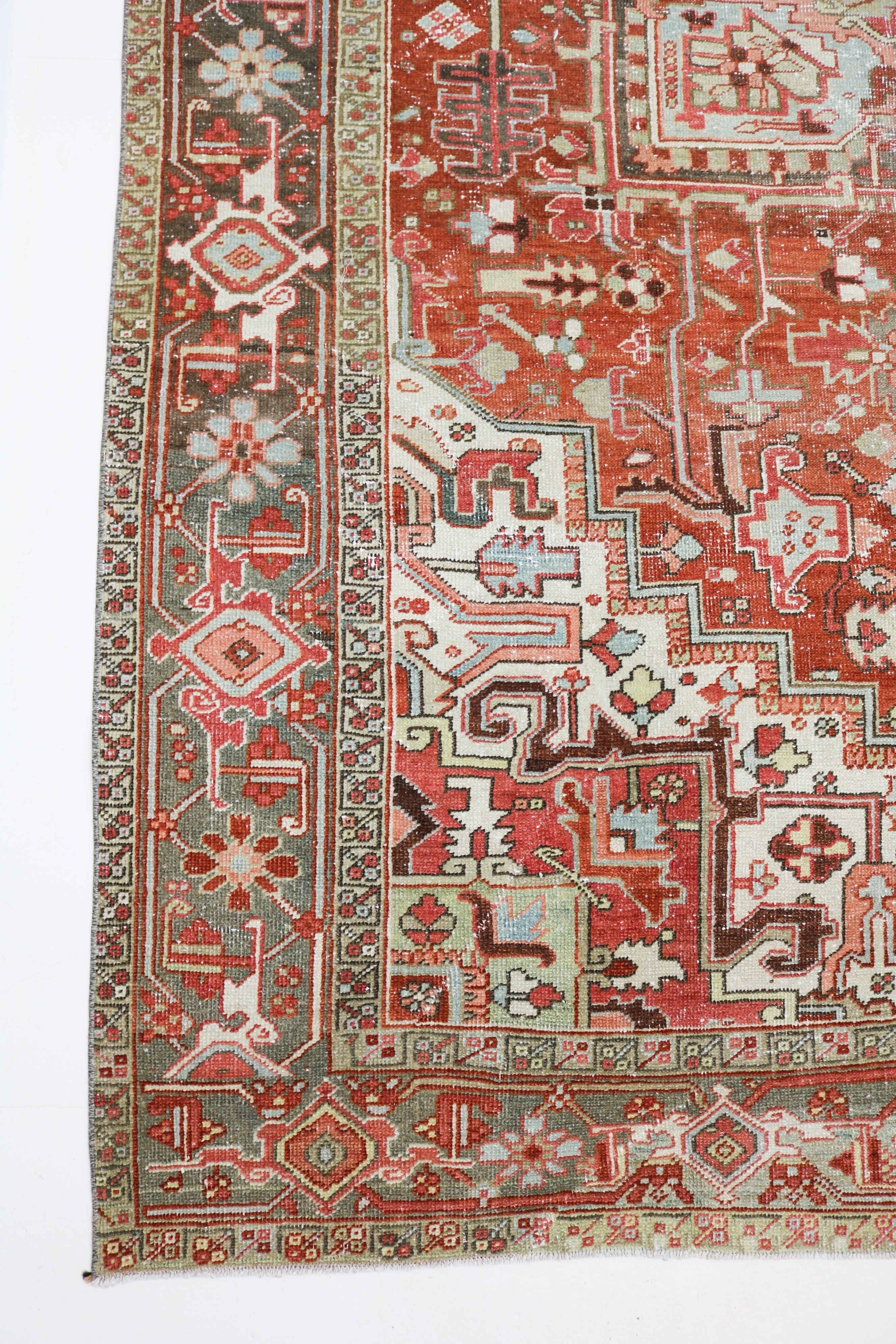 Antique Persian Heriz rug circa 1920, 340 × 240 cm, with terracotta field and large geometric medallion