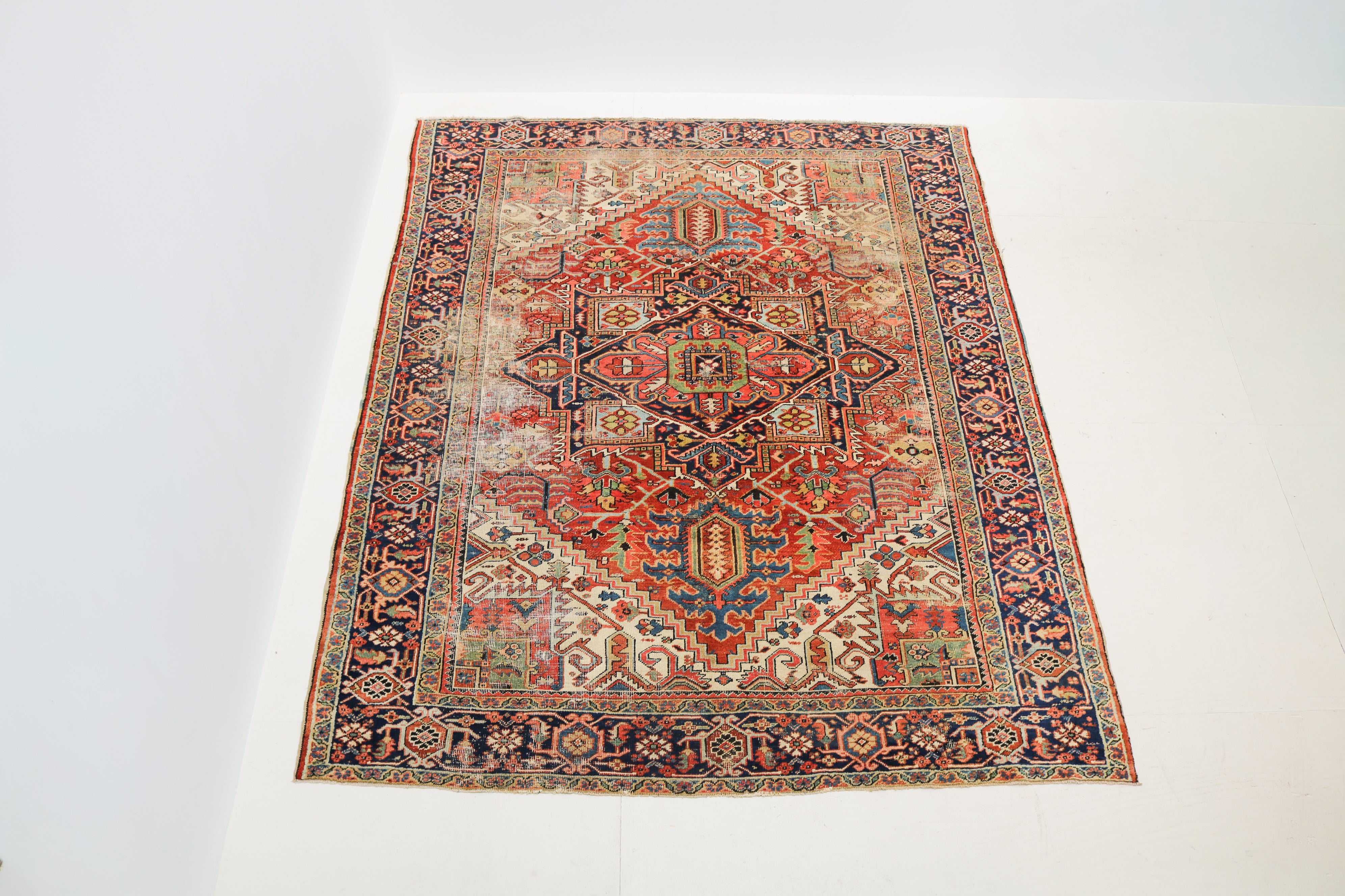 Antique Heriz rug detail with terracotta, navy blue, ivory, green and pale blue geometric motifs