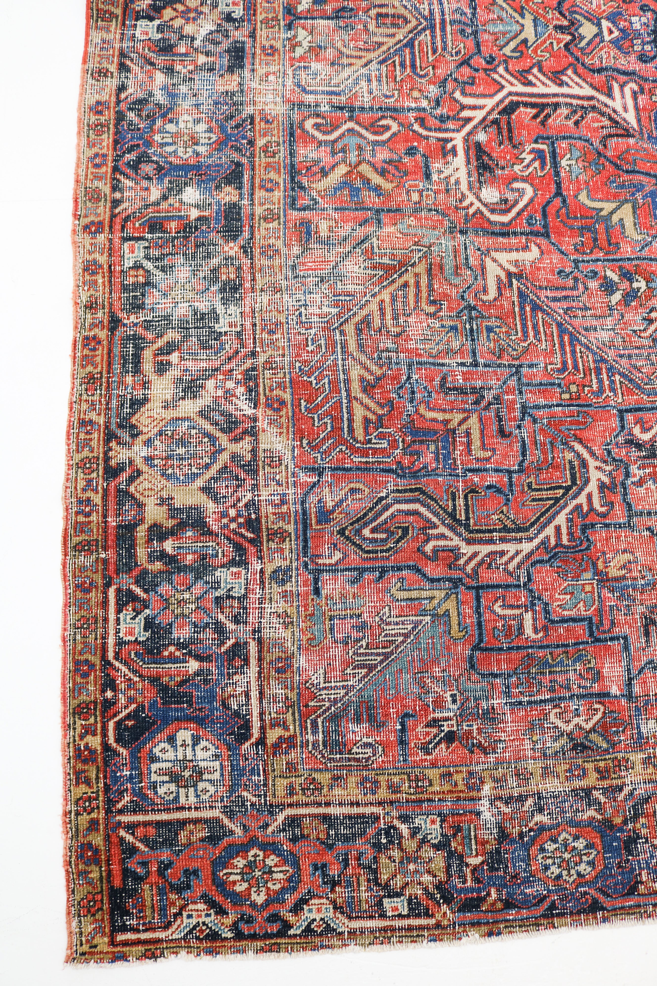 Close-up of antique Persian Heriz rug showing geometric motifs, naturally worn wool pile and aged patina