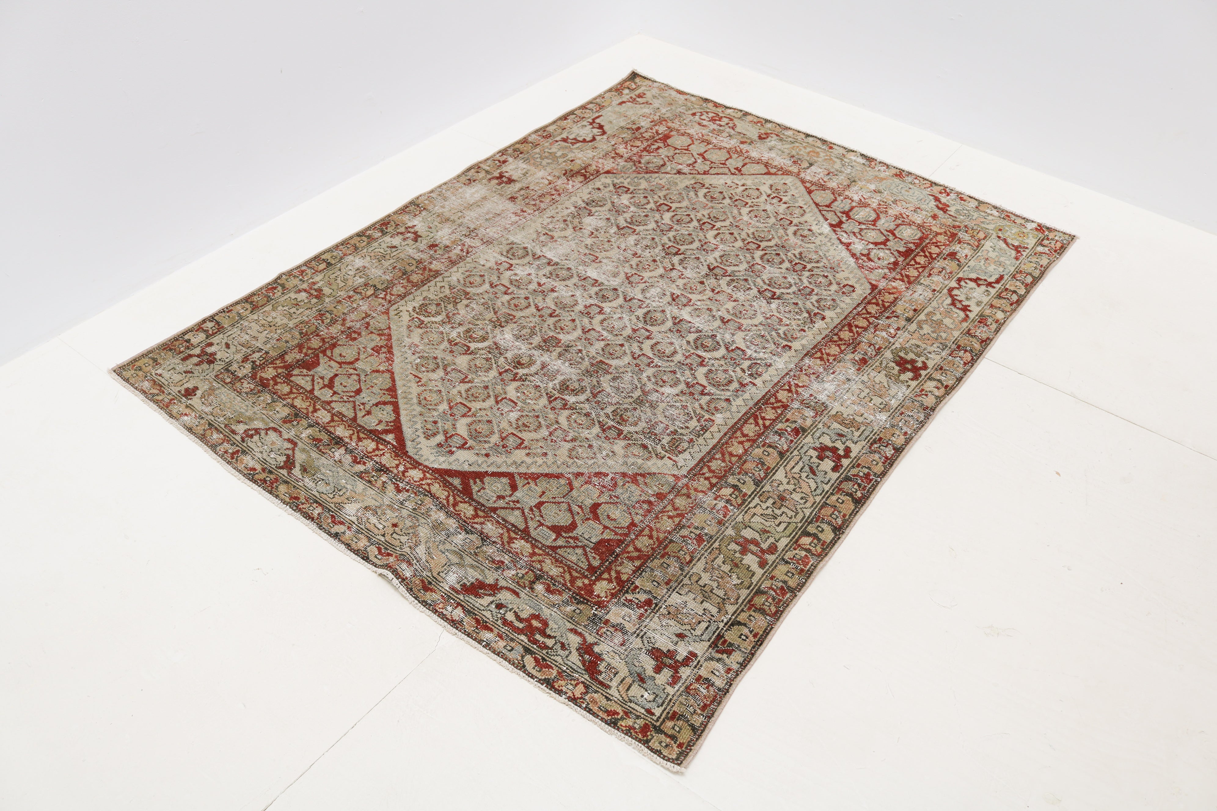 Circa 1920 Persian Malayer rug with distressed low pile and muted red and neutral colours