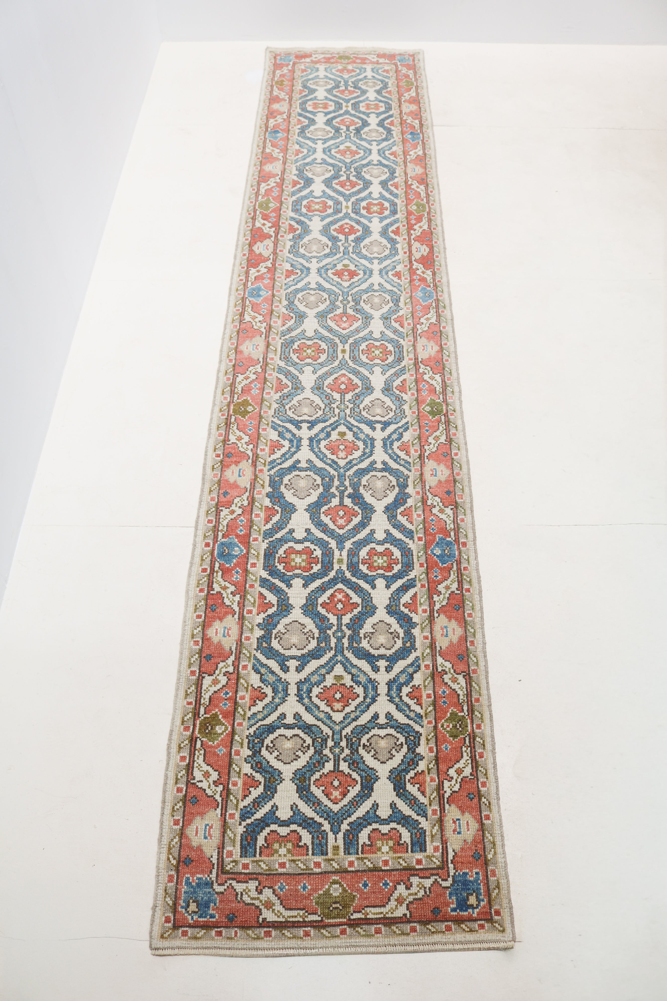 Close-up of vintage Turkish Ushak Runner showing coral red and blue border