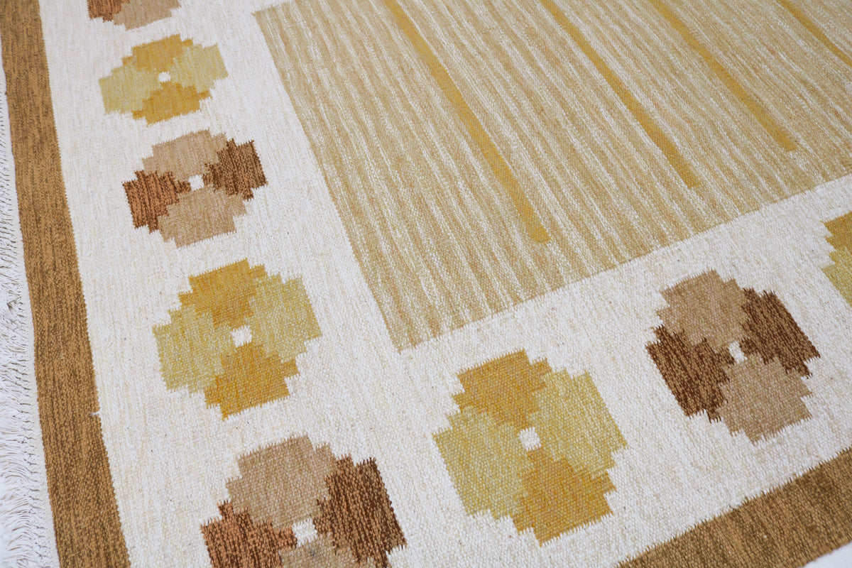 Detailed view of Swedish Kilim rug with warm golden field and repeating geometric patterns