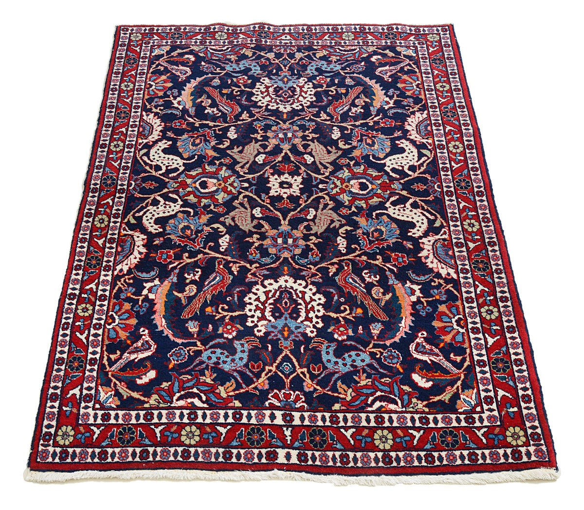 Full view of vintage Persian Mashhad rug with dense floral design and ornate borders