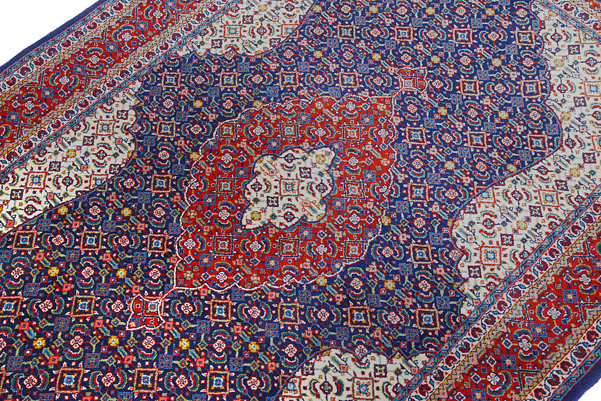 Close-up of vintage Sarouk rug showing intricate navy, red and ivory motifs
