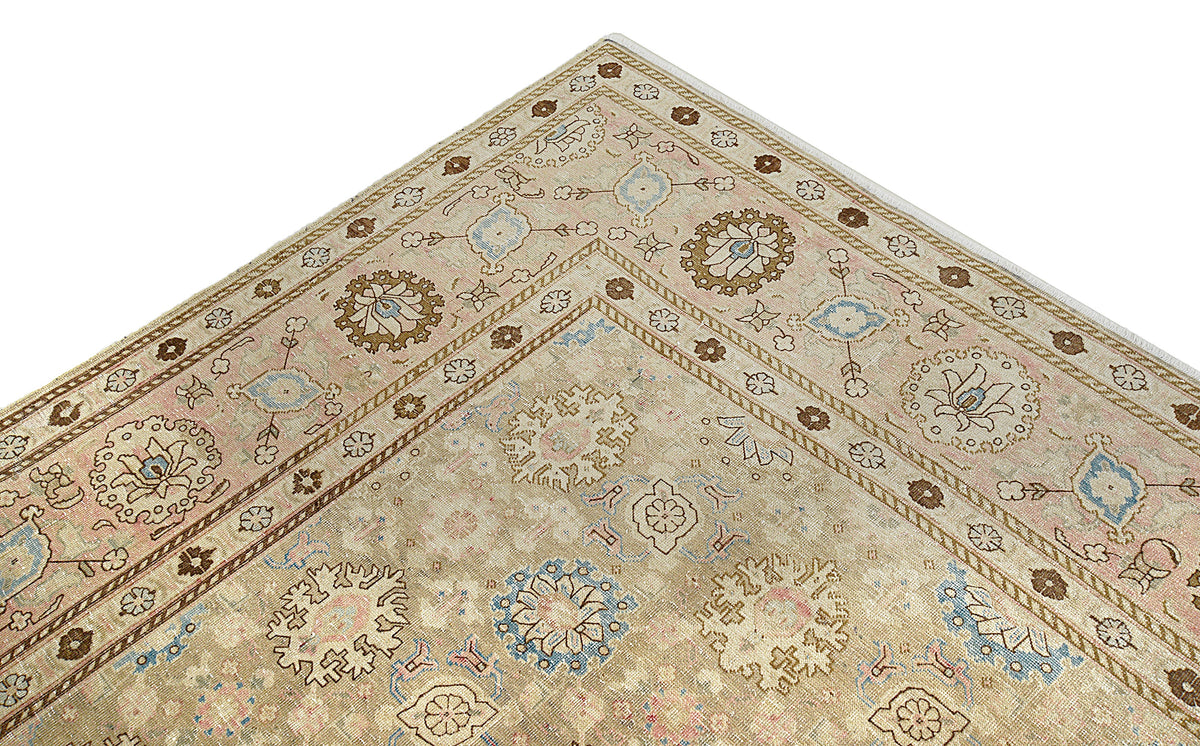 Close-up of antique Tabriz carpet corner with floral motifs and layered borders