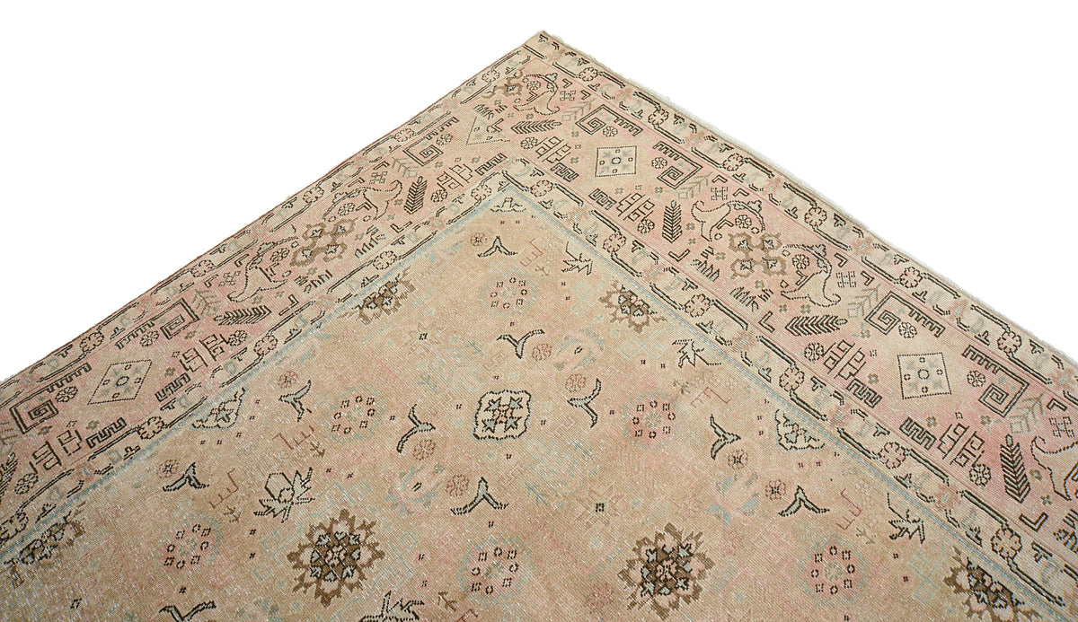 Close-up of antique-style Tabriz carpet corner with delicate motifs and layered border
