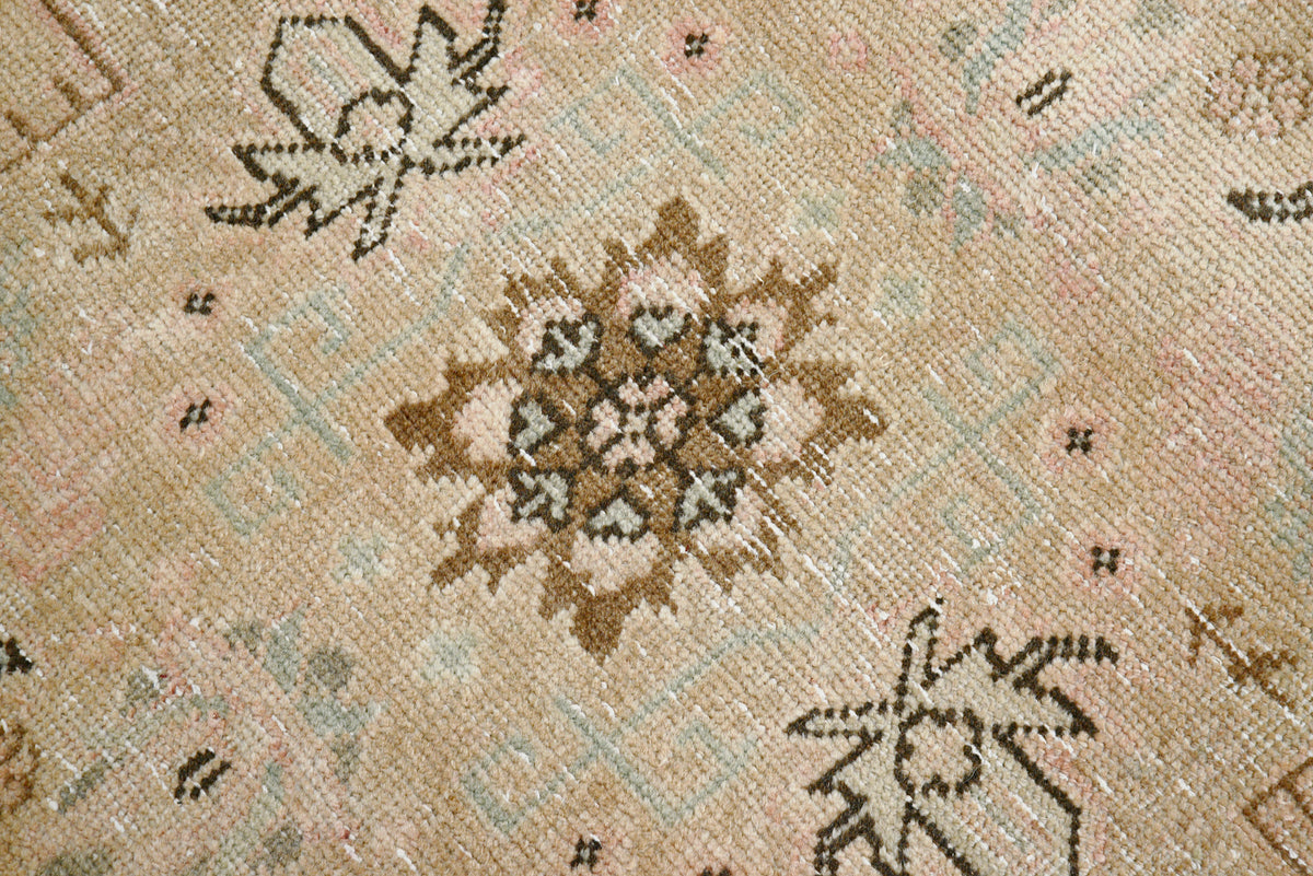 Detailed Tabriz carpet field with softly drawn floral motifs in beige and blush tones
