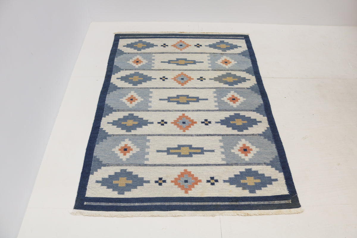 Full view of vintage Swedish Kilim rug with alternating geometric motifs and striped bands