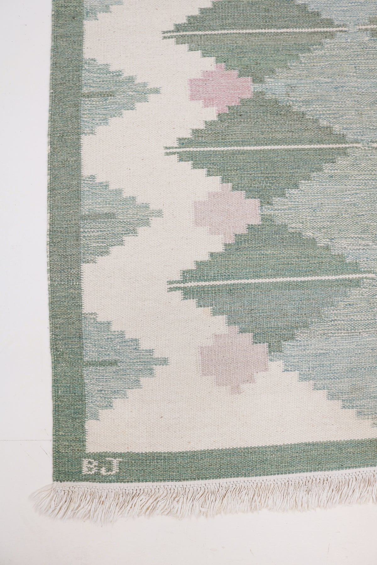 Vintage Swedish Kilim rug with sage green diamond motifs on an ivory field and simple border